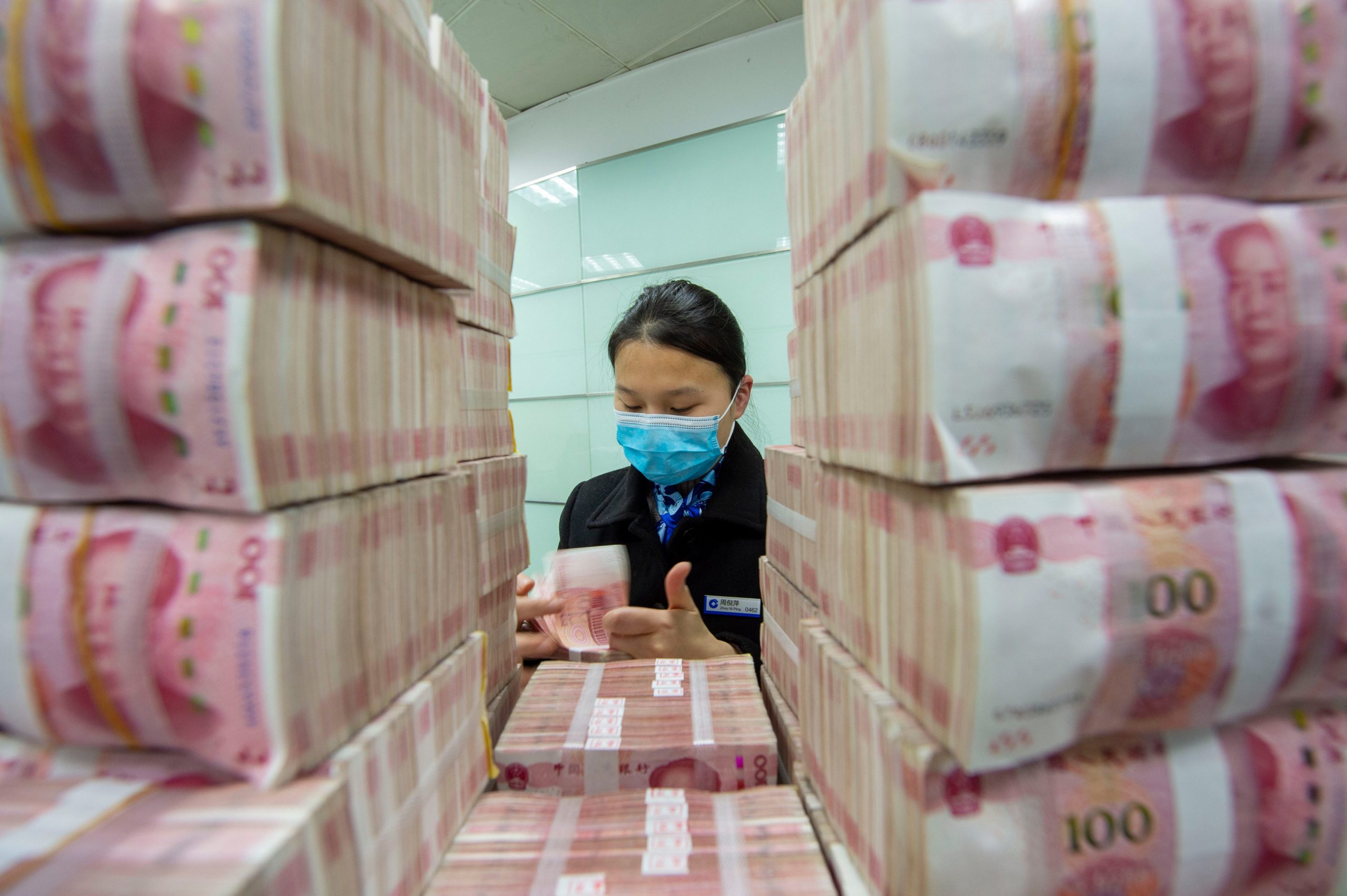 A clerk counts renminbi banknotes at a bank outlet in Haian city in east Chinas Jiangsu province.