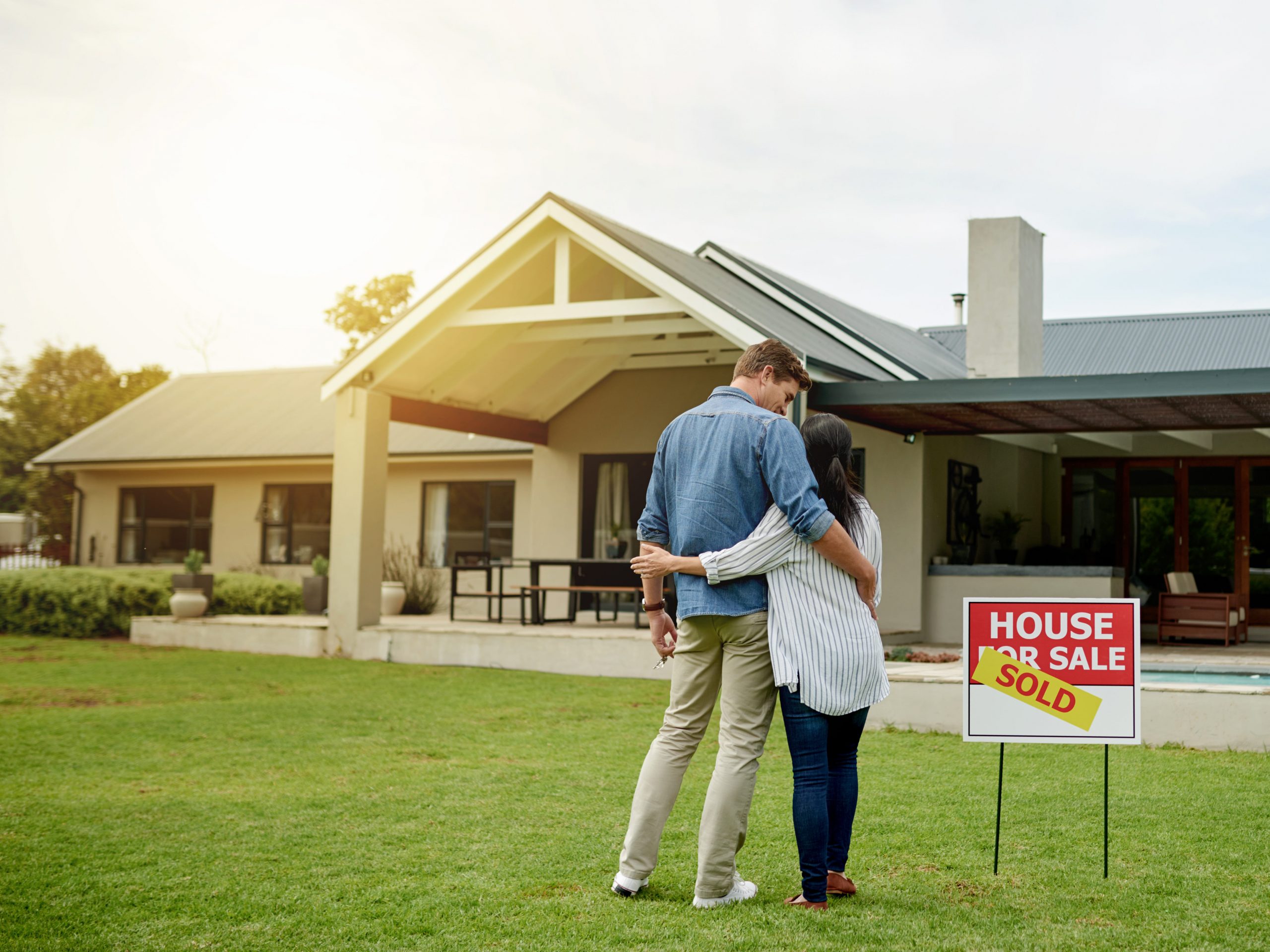 A couple standing in front of a home.