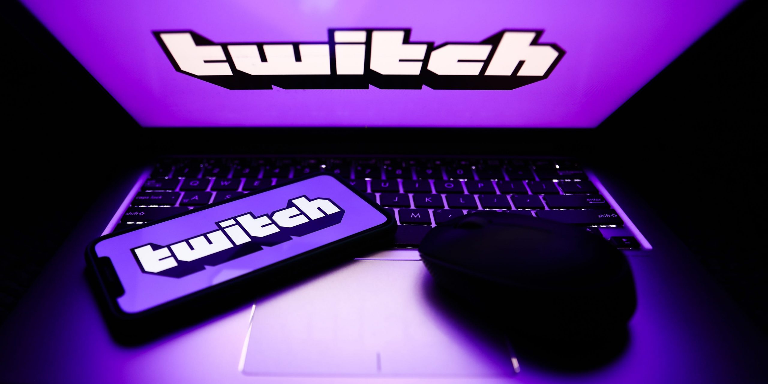 Twitch logos are seen displayed on a phone and a laptop screens in this illustration photo.