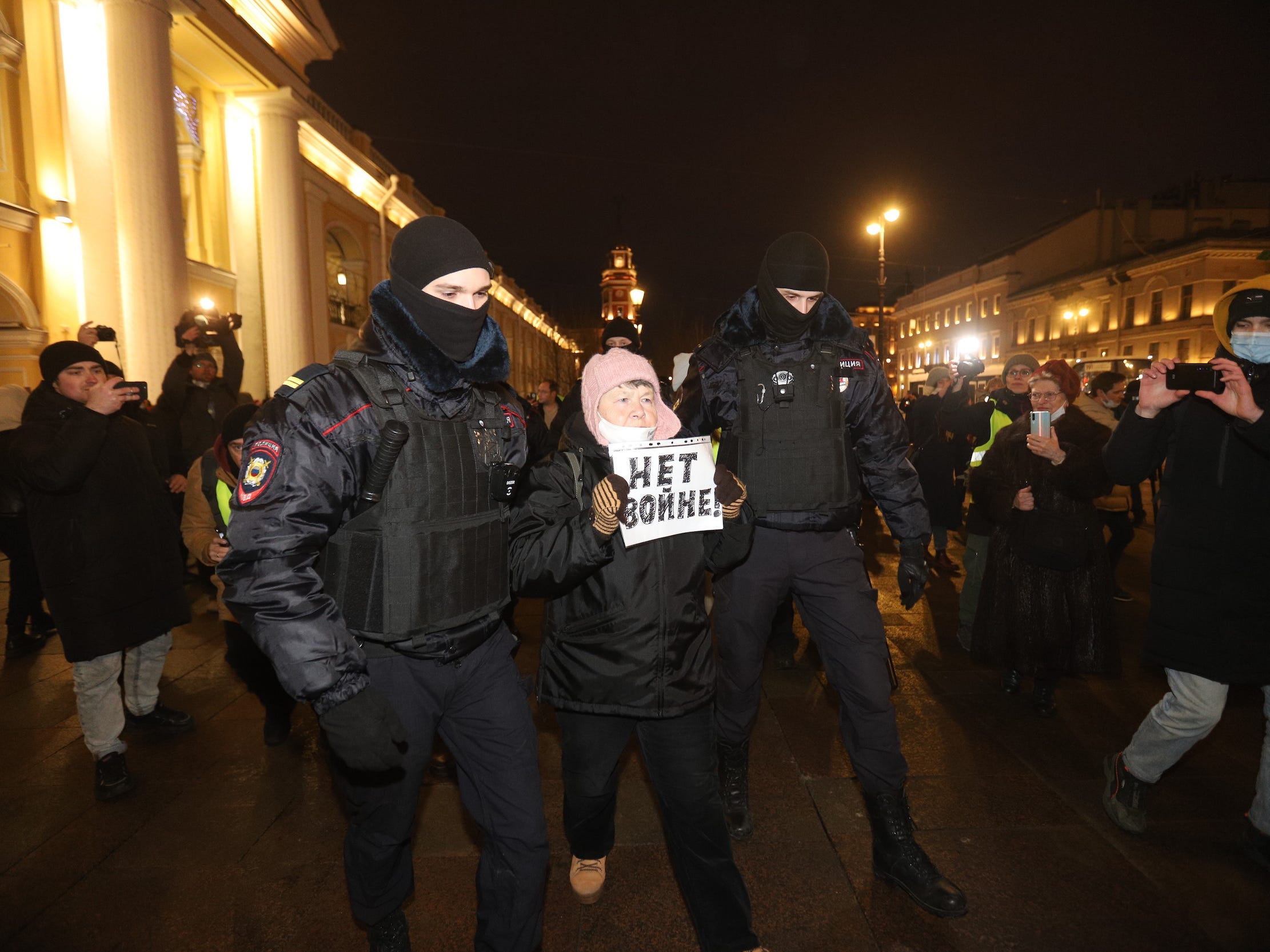 Security forces detain a woman holding a “No war” sign at an anti-war demonstration on February 24, 2022 in St. Petersburg, Russia.