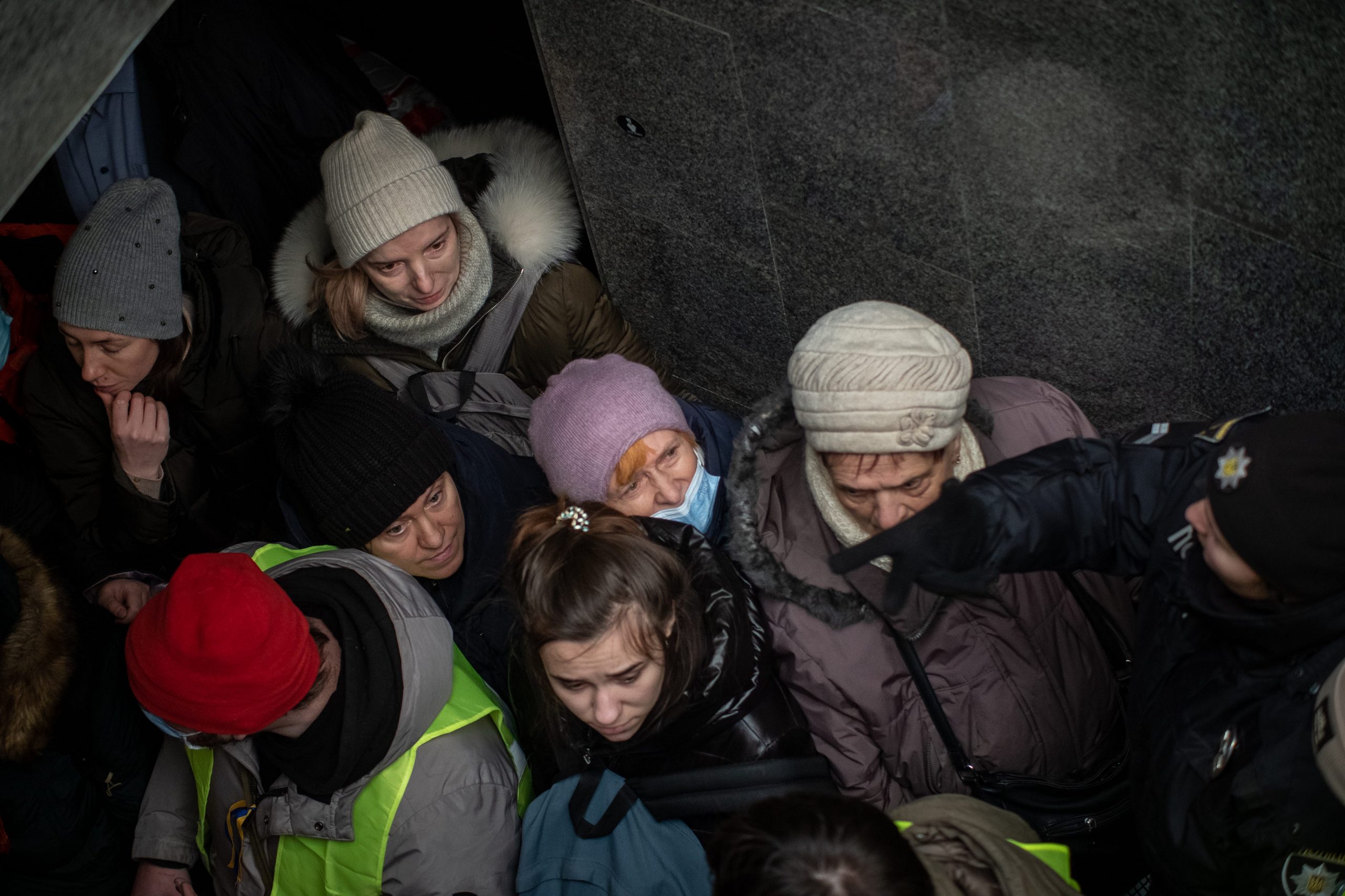 Women are seen from above as they wait to board a train to Poland at Lviv's train station.