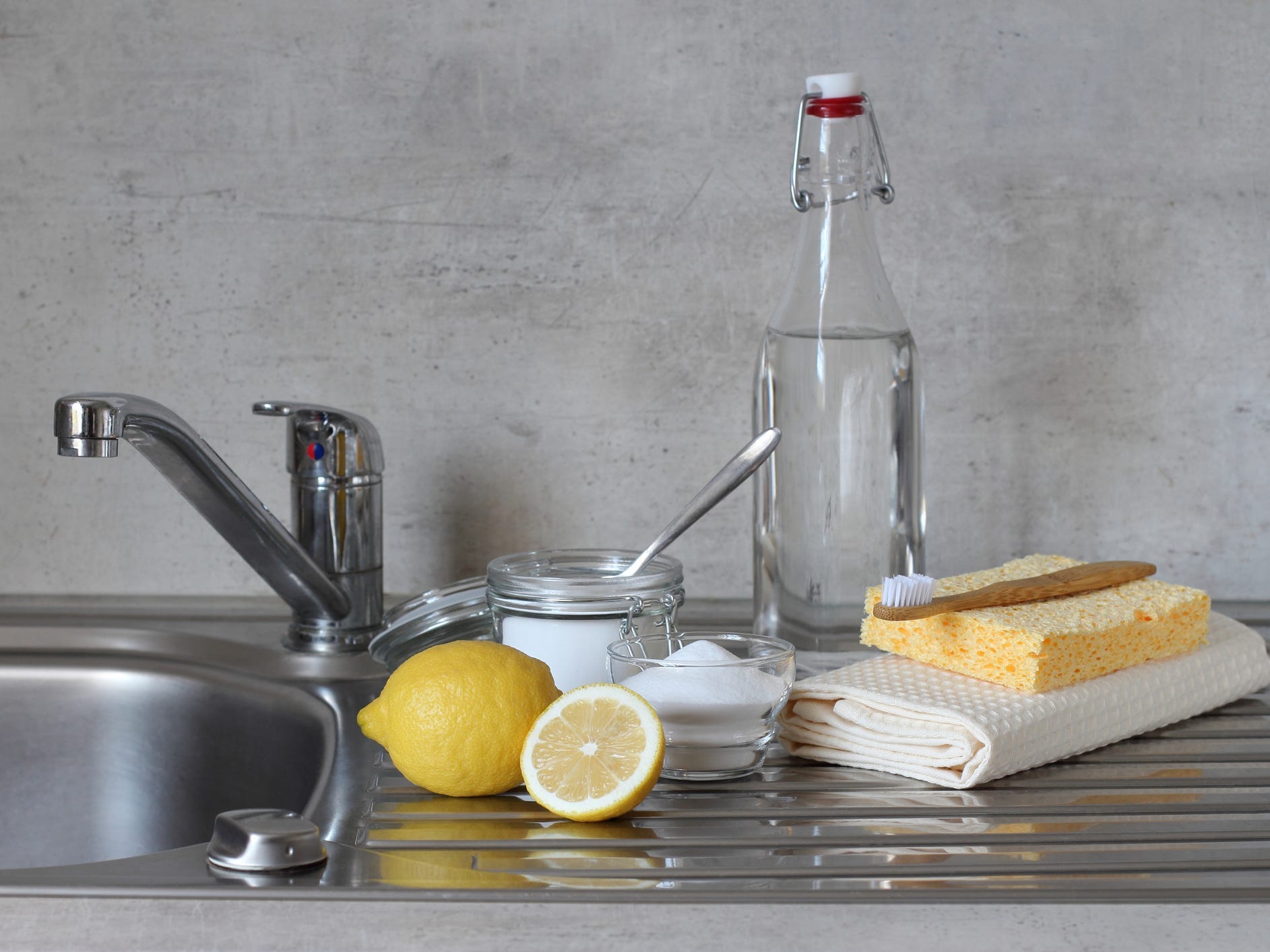 Baking soda, lemons, and vinegar next to a sink