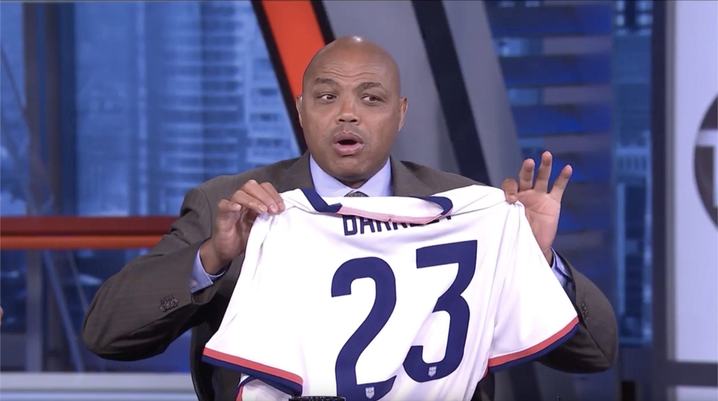 Charles Barkley holds up his women's US soccer jersey.