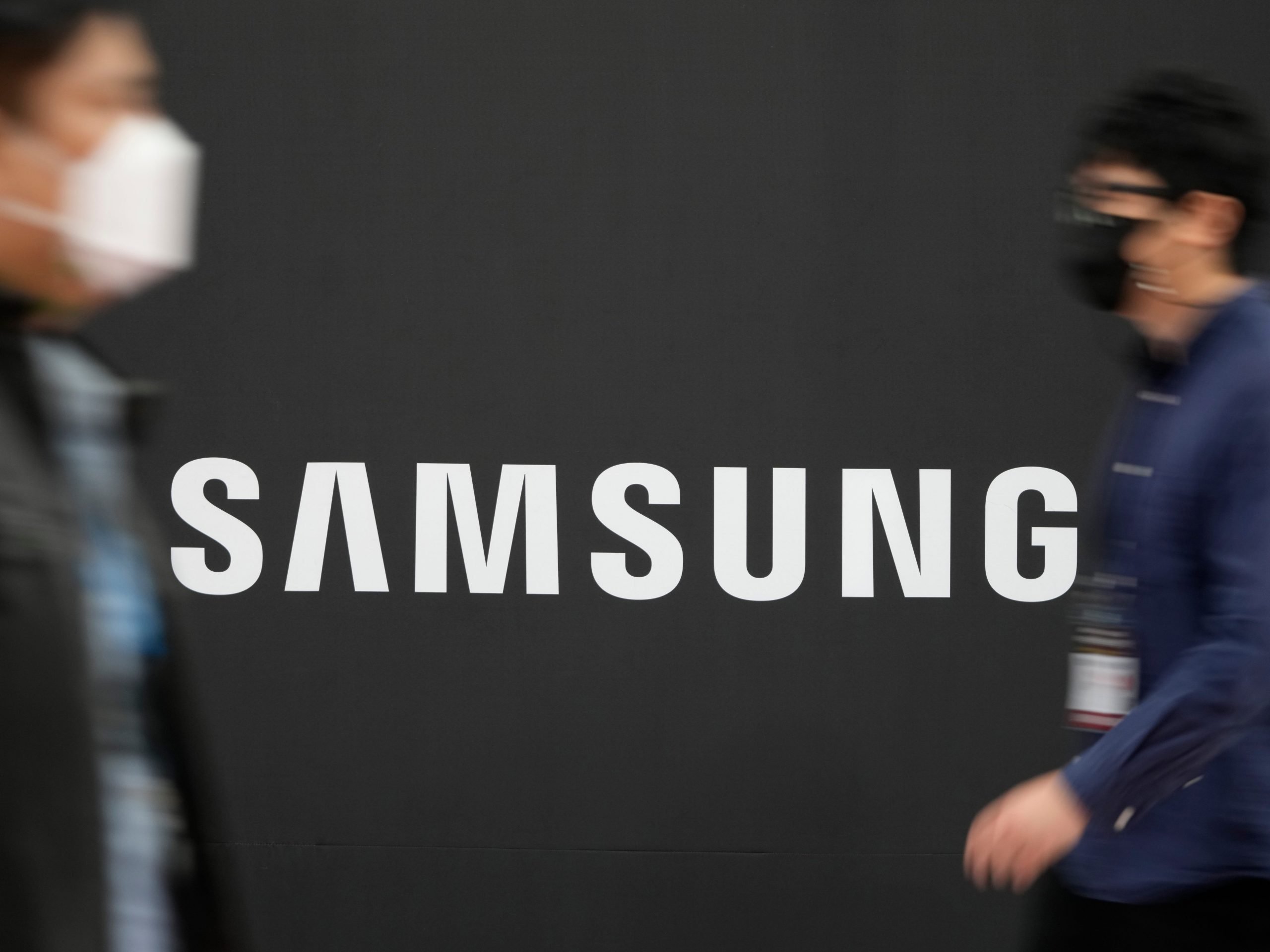 Visitors walk past the logo of Samsung Electronics at a semiconductor exhibition in Seoul, South Korea.