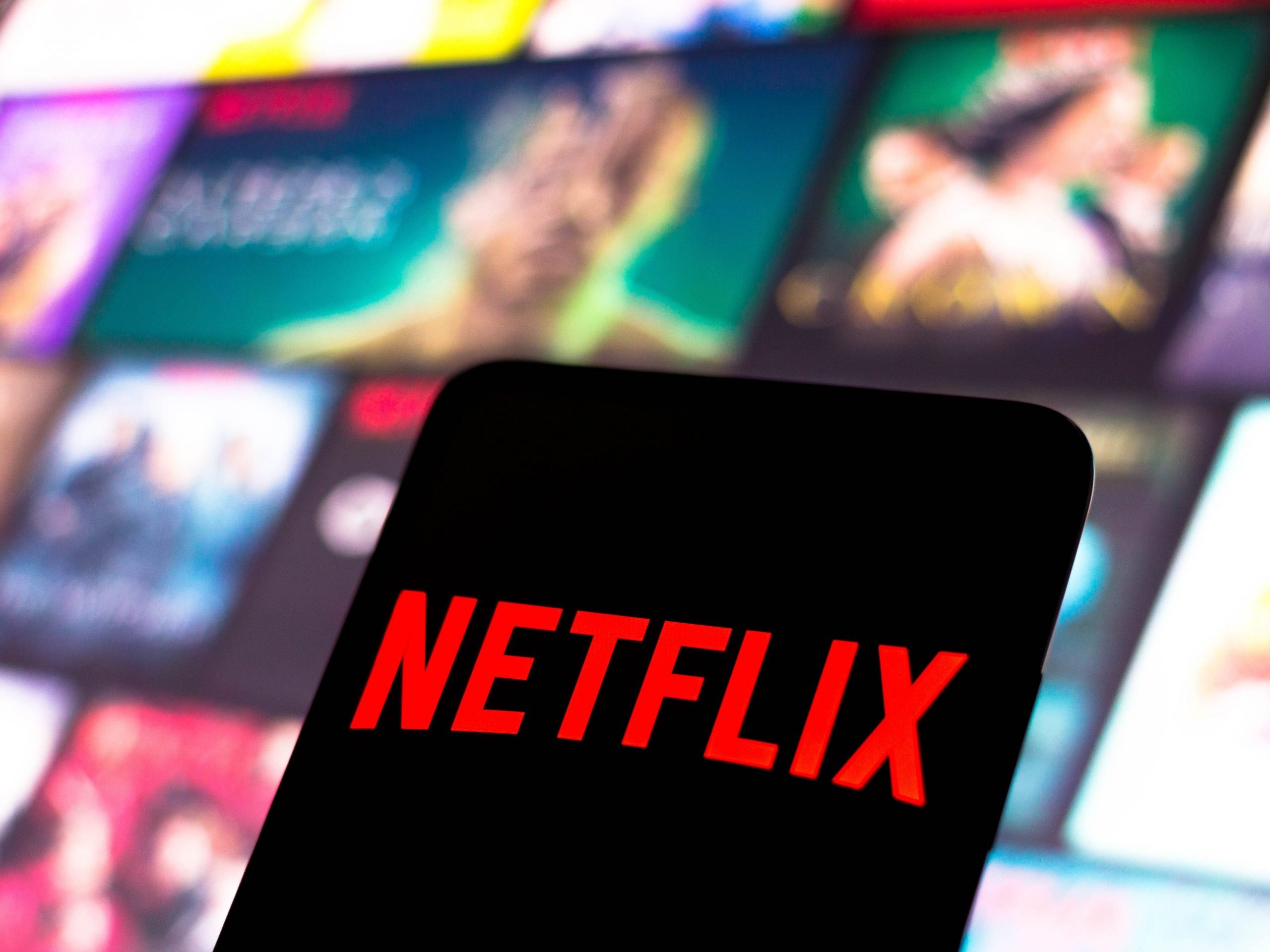 The Netflix logo is displayed on a smartphone screen.