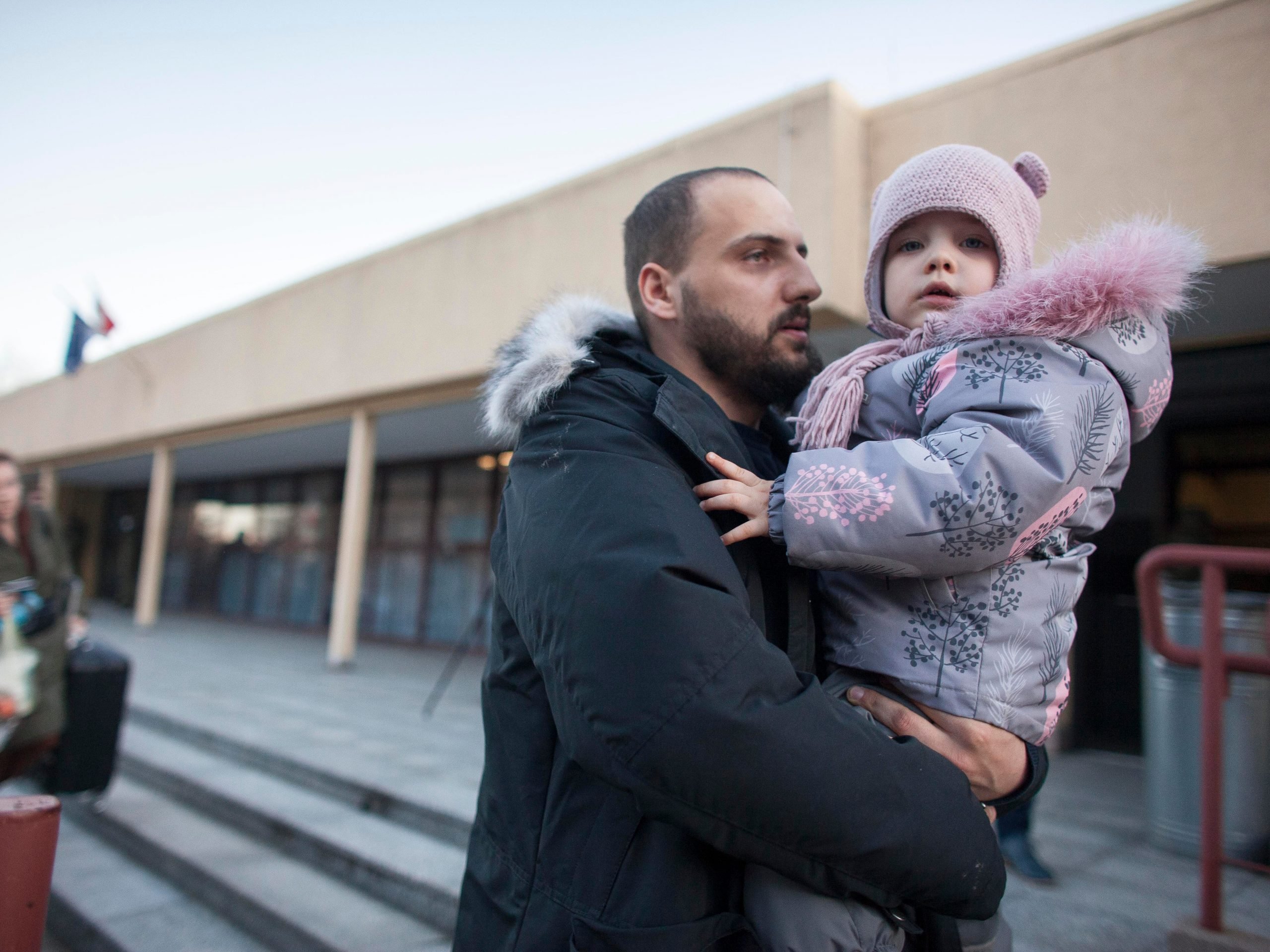 A man holds a young girl in his arms.