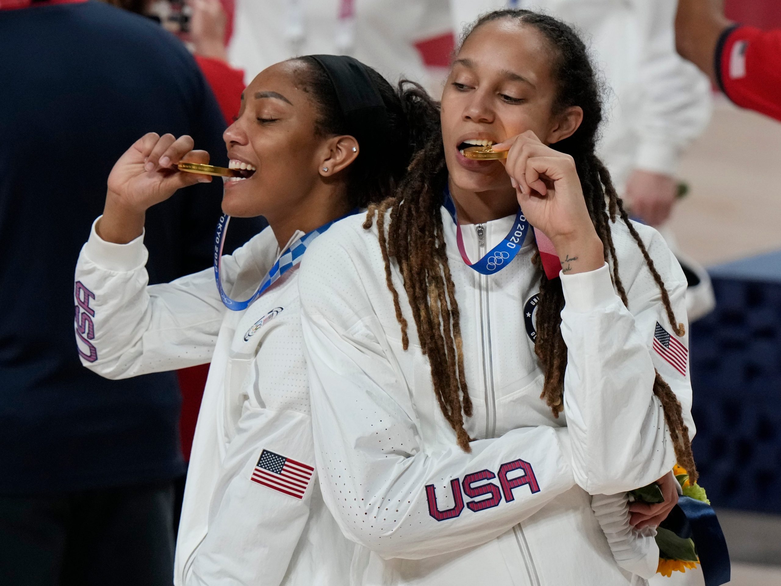 Brittney Griner, right, and A'Ja Wilson bite their gold medals.