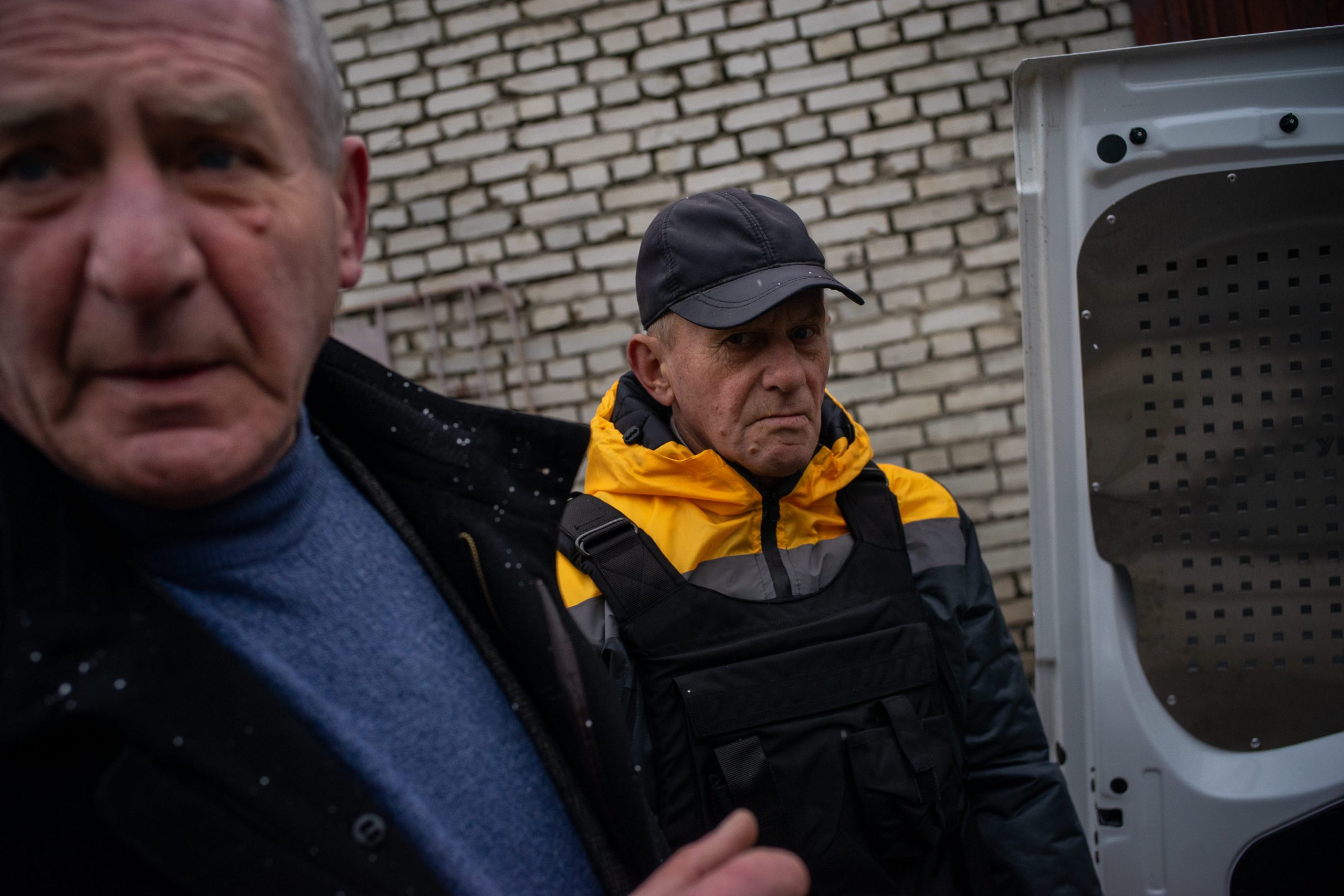 Two men standing outside an open van door.