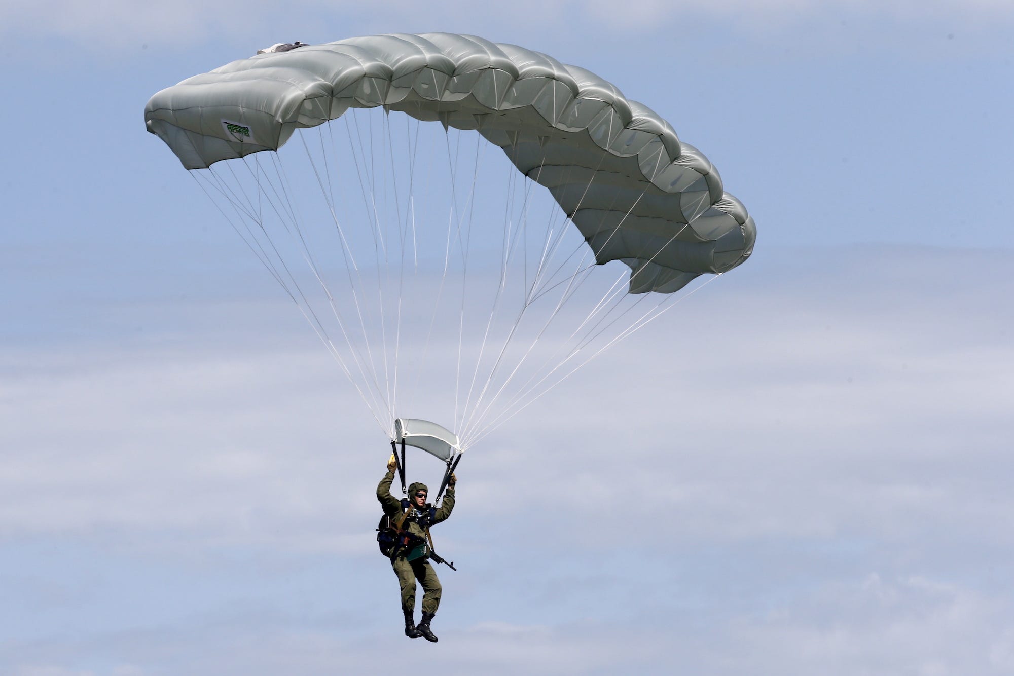 Een lid van een speciale eenheid van het Russische leger springt met een parachute uit een helikopter tijdens een oefening op 7 juni 2019. Foto: Valery MatytsinTASS via Getty Images