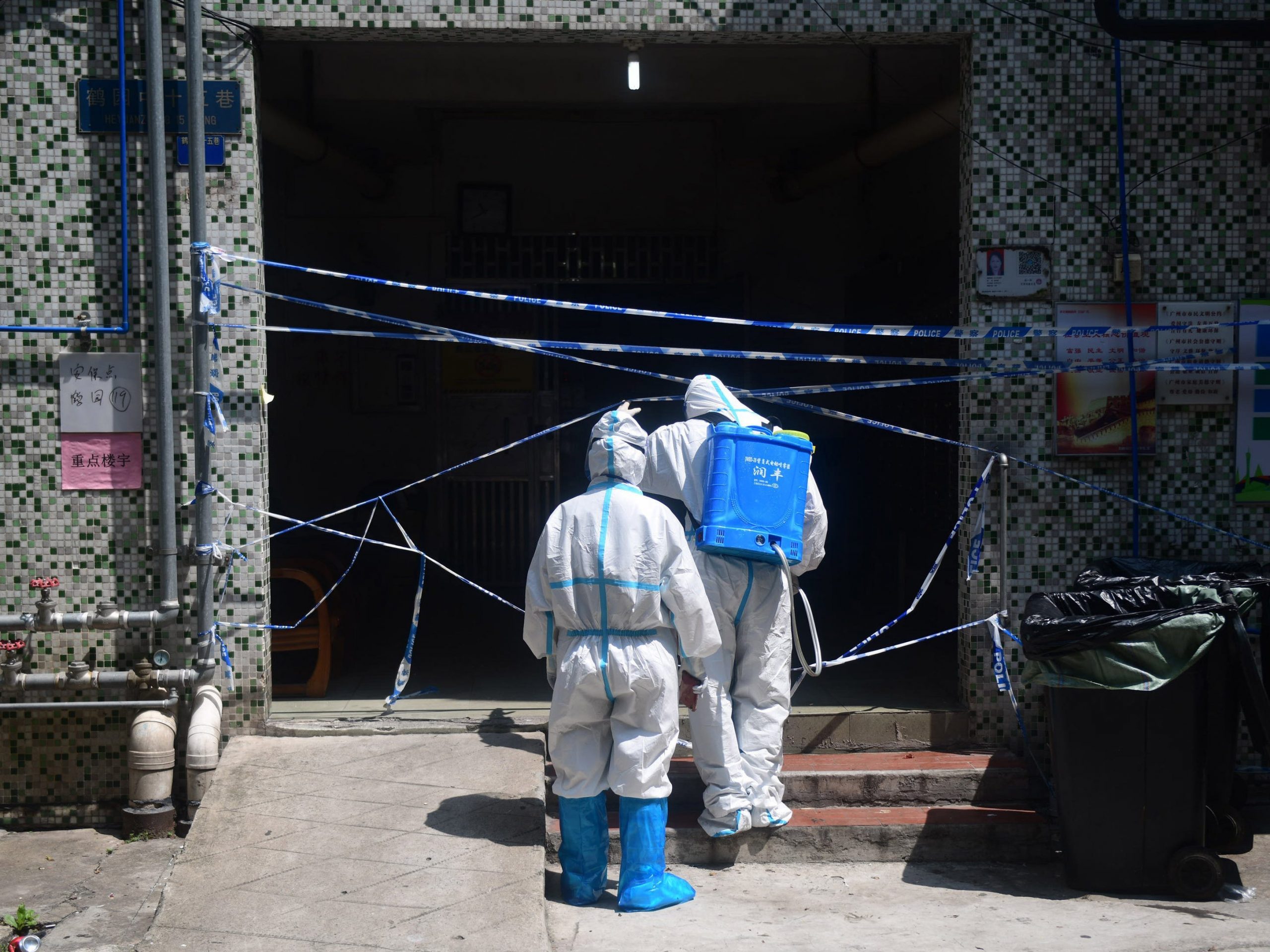 Volunteers wearing protective suits disinfects a residential community under closed-off management on June 6, 2021 in Guangzhou, Guangdong Province of China