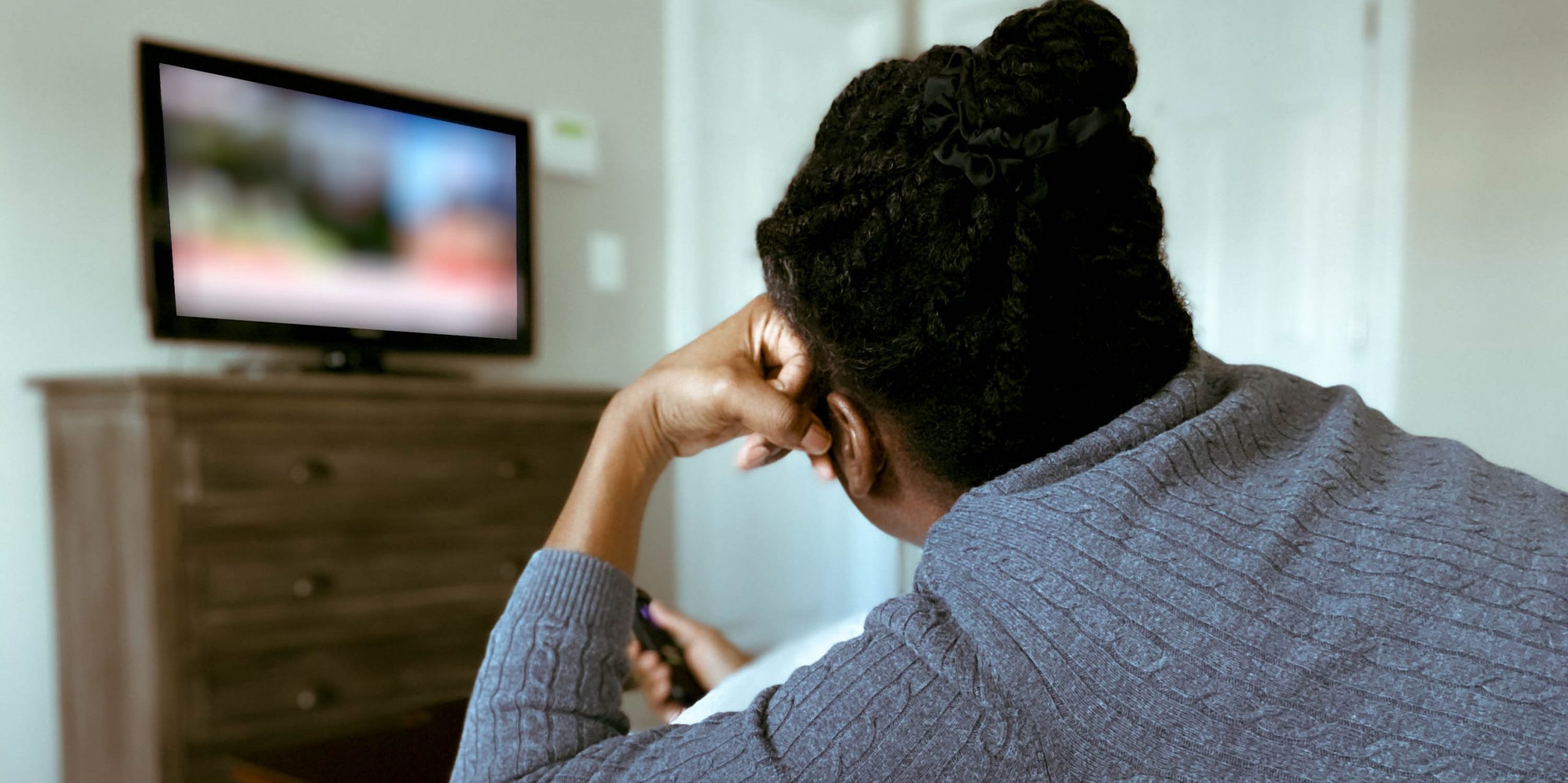 woman watching tv on bed