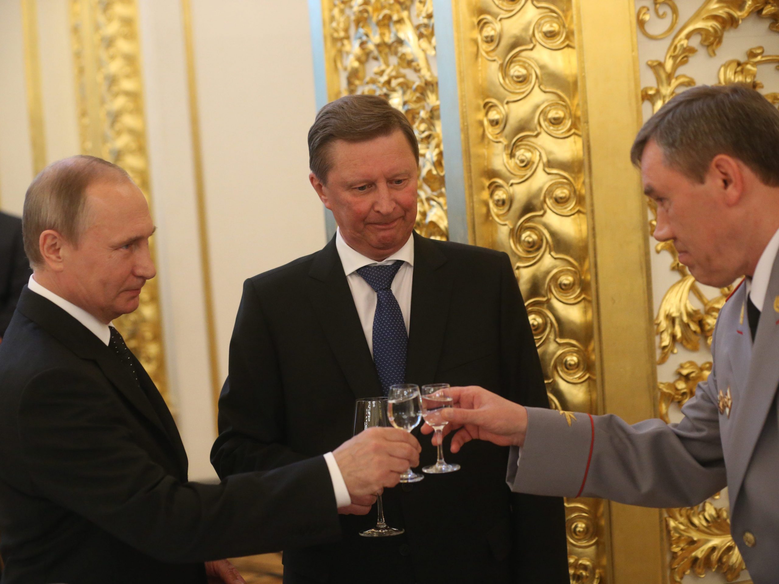 Russian President Vladimir Putin (L) toasts holding a glass of vodka with Deputy Defence Minister Valery Gerasimov (R) as Presidential Administration Chief of Staff Sergei Ivanov (C).