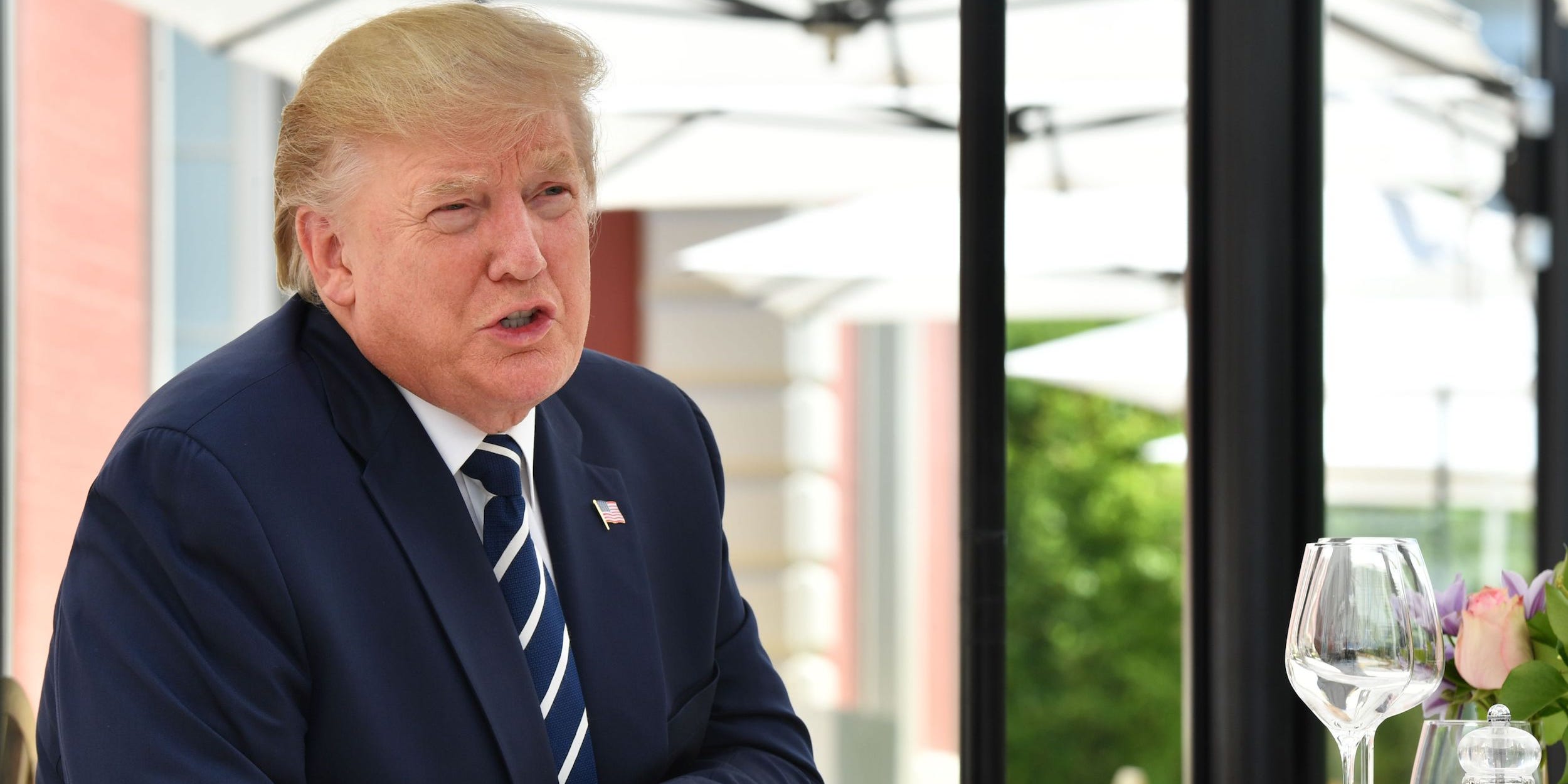 Donald Trump leans on his chair at a dinner table.