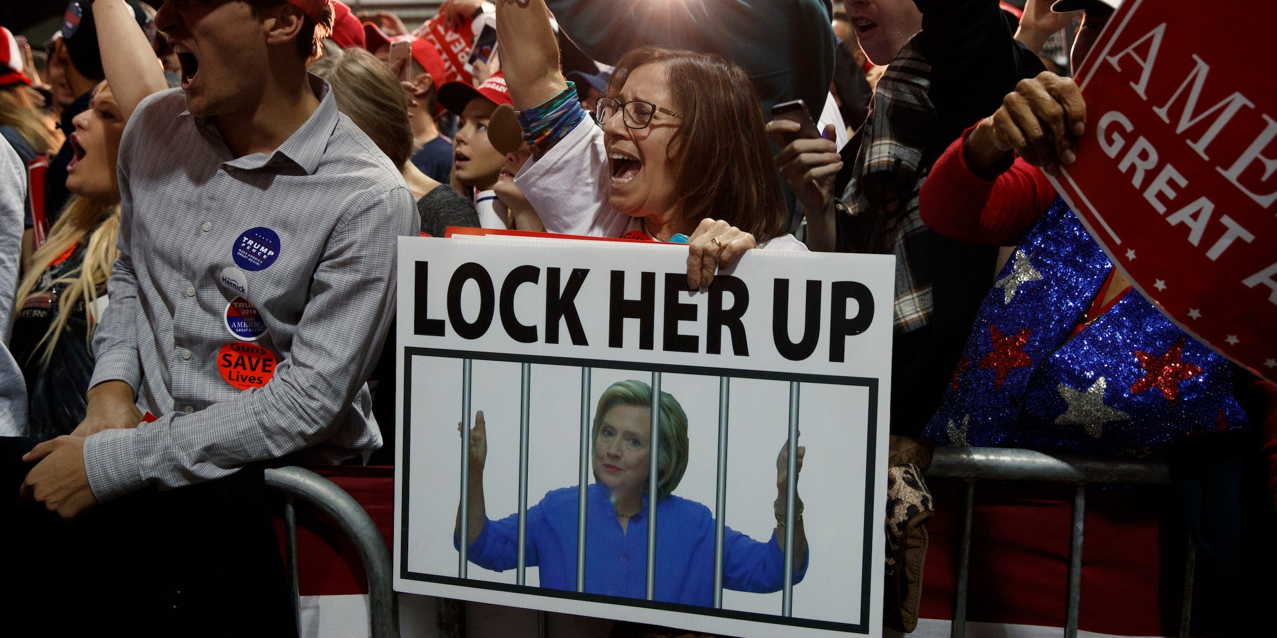 A Trump supporter holds a "Lock her up" sign in 2016