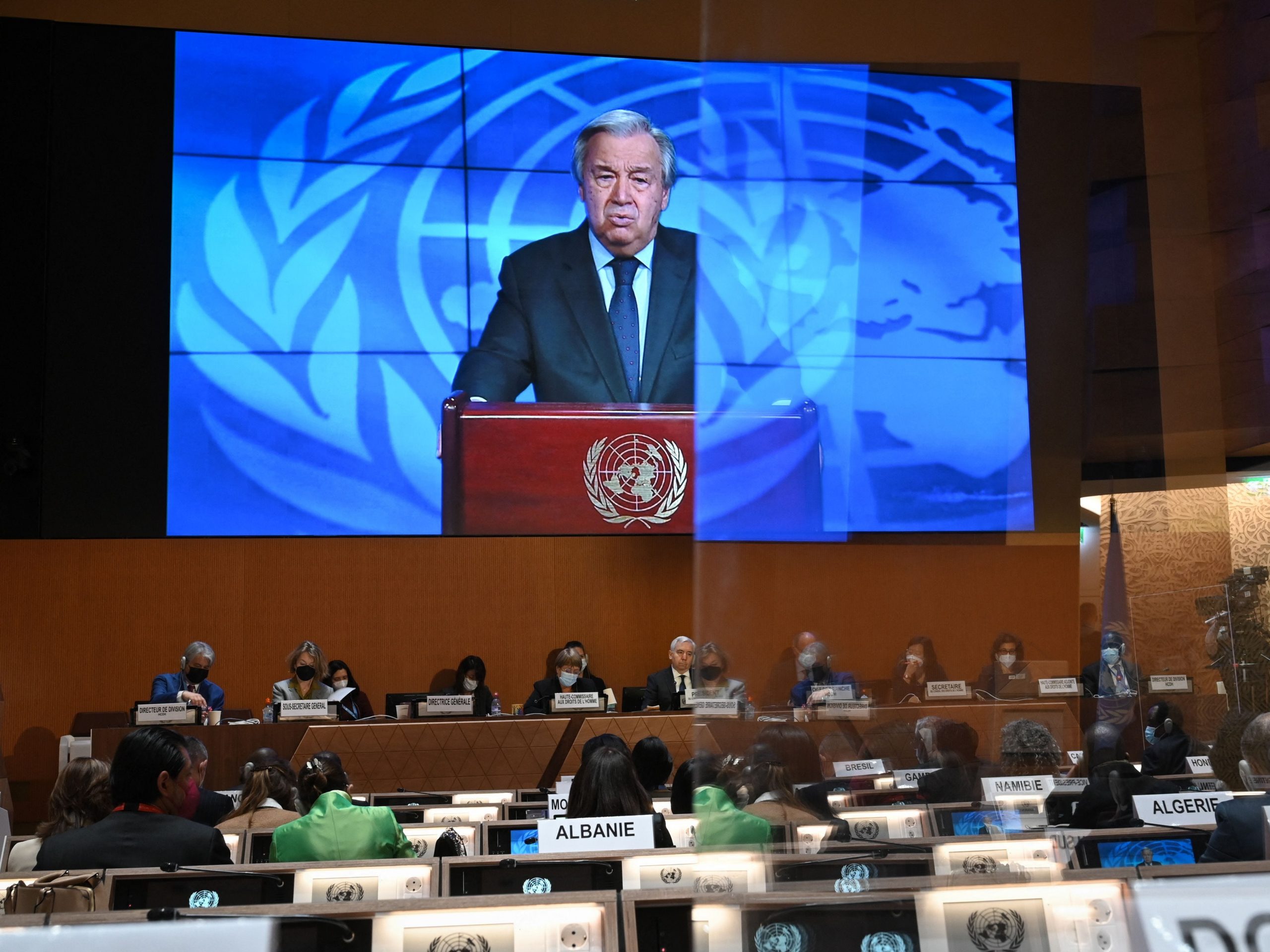 UN Secretary-General Antonio Guterres appears on a screen as he delivers a remote speech at the opening of a session of the UN Human Rights Council on February 28, 2022 in Geneva.