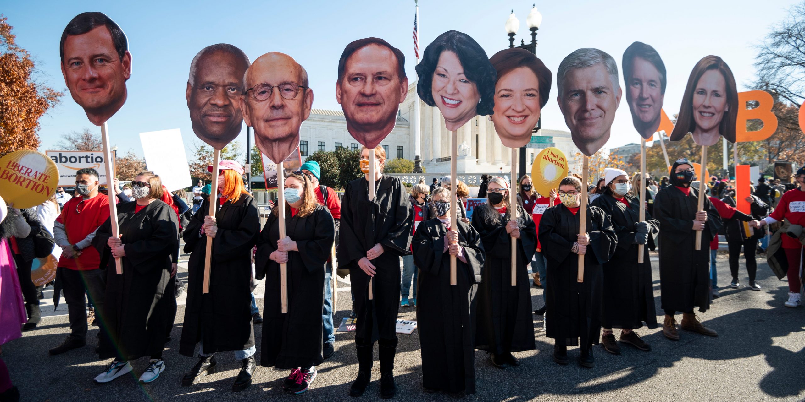 Pro-abortion activists hold cutout signs with the faces of Supreme Court justices outside the Supreme Court in December 2021.