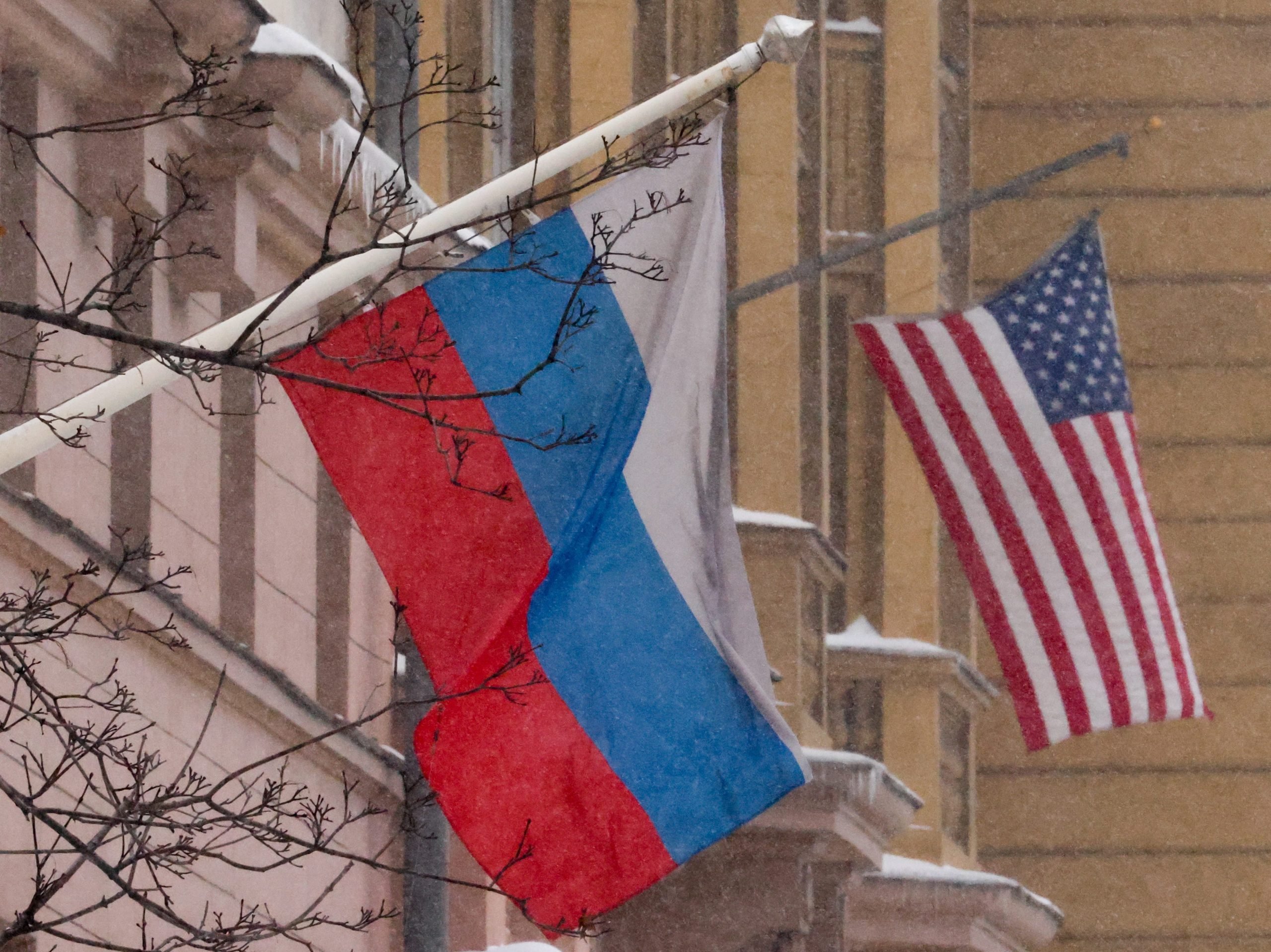 A Russian flag and American flag outside a building.