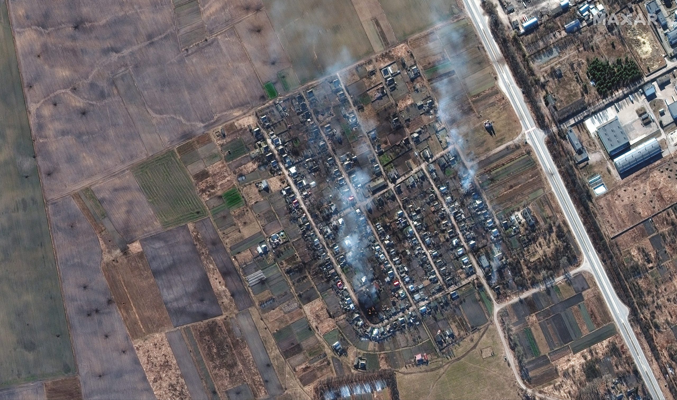 Maxar satellite imagery overview of burning homes and impact craters in field Rivnopillya, Ukraine.