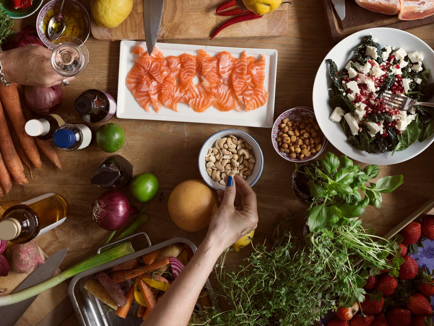 a table fulll of Nordic-style foods such as salmon, greens, nuts, and berries