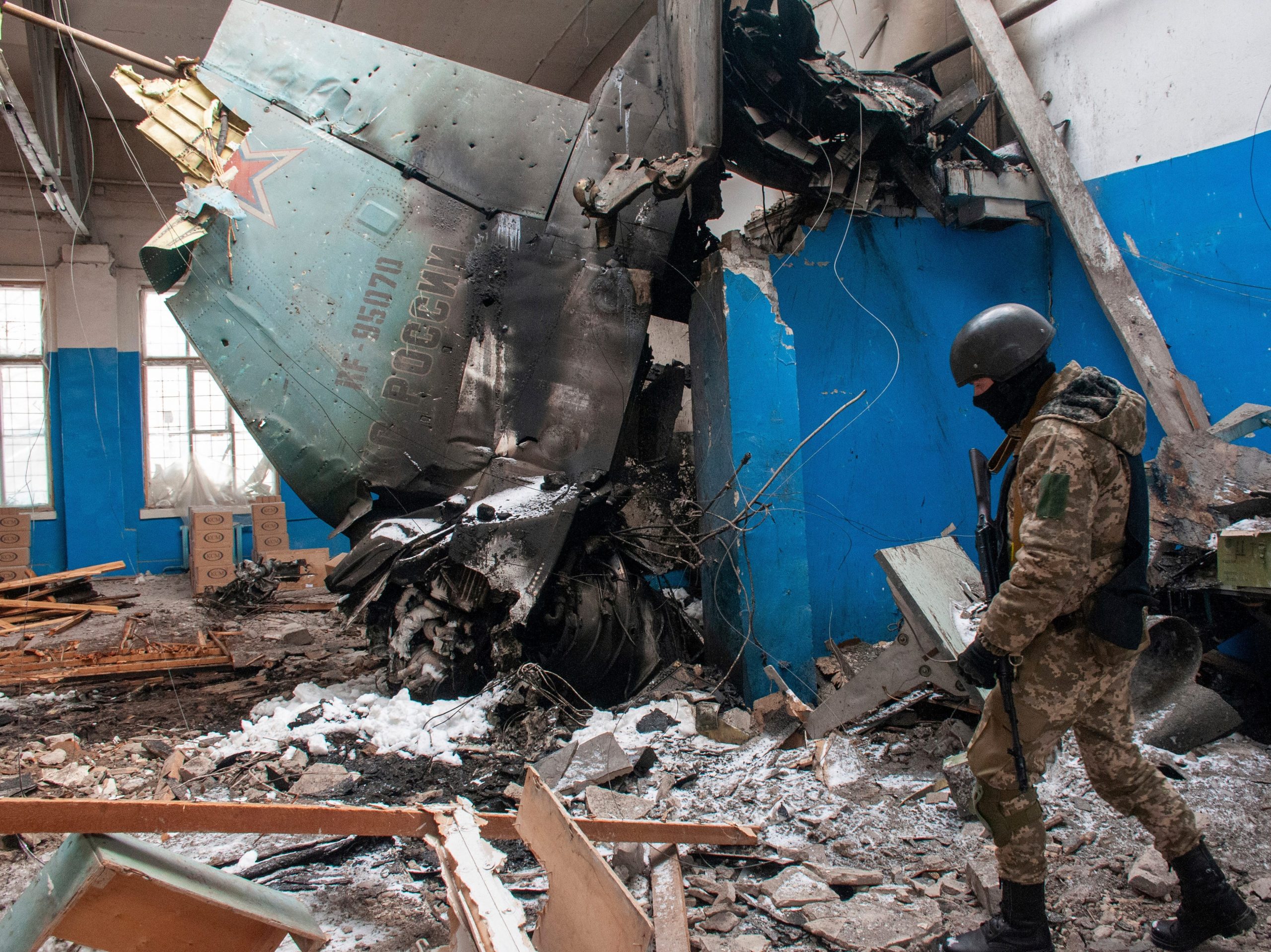 A Ukrainian serviceman walks past the vertical tail fin of a Russian Su-34 bomber lying in a damaged building in Kharkiv, Ukraine, Tuesday, March 8, 2022.