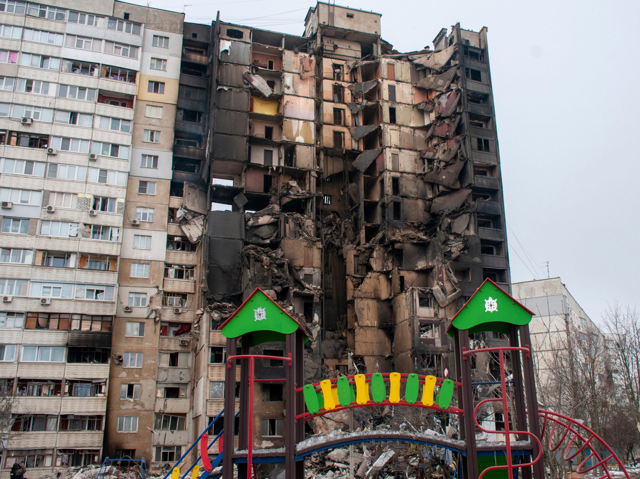 A children's playground is seen in front of an apartment building hit by shelling in Kharkiv, Ukraine, Tuesday, March 8, 2022.