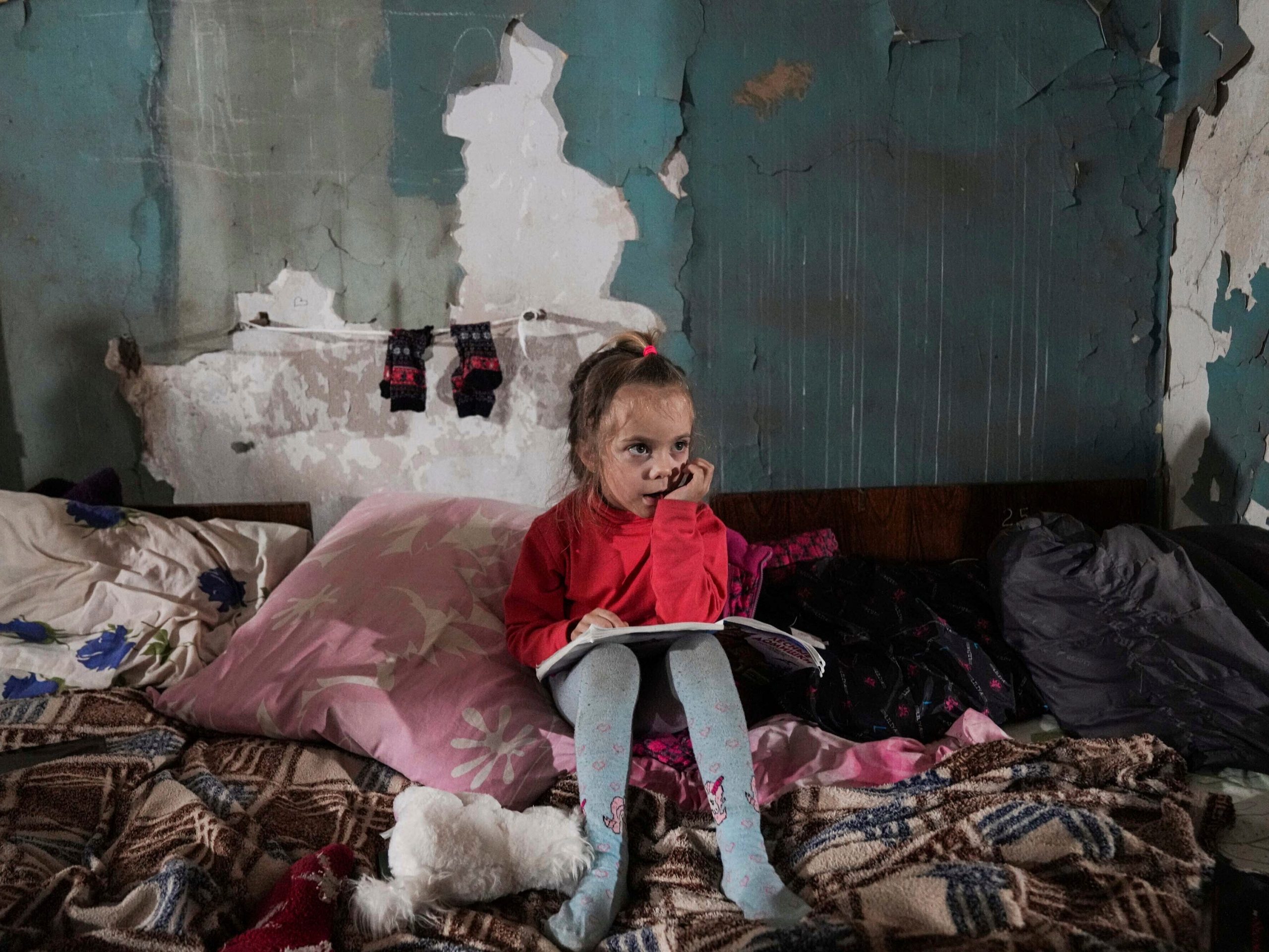 A girl sits in an improvised bomb shelter in Mariupol, Ukraine.