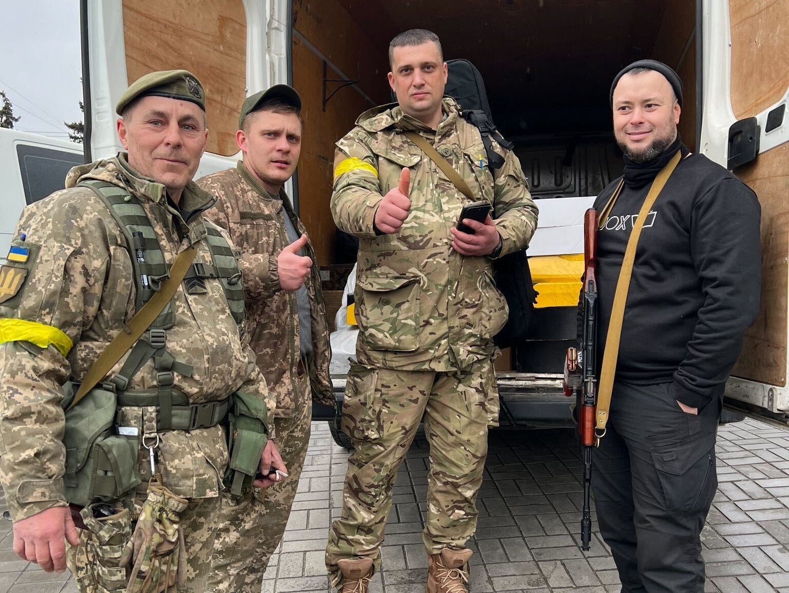 Ukrainian soldiers and volunteers give a thumbs while on a supply run around the city of Zaporizhzhia.