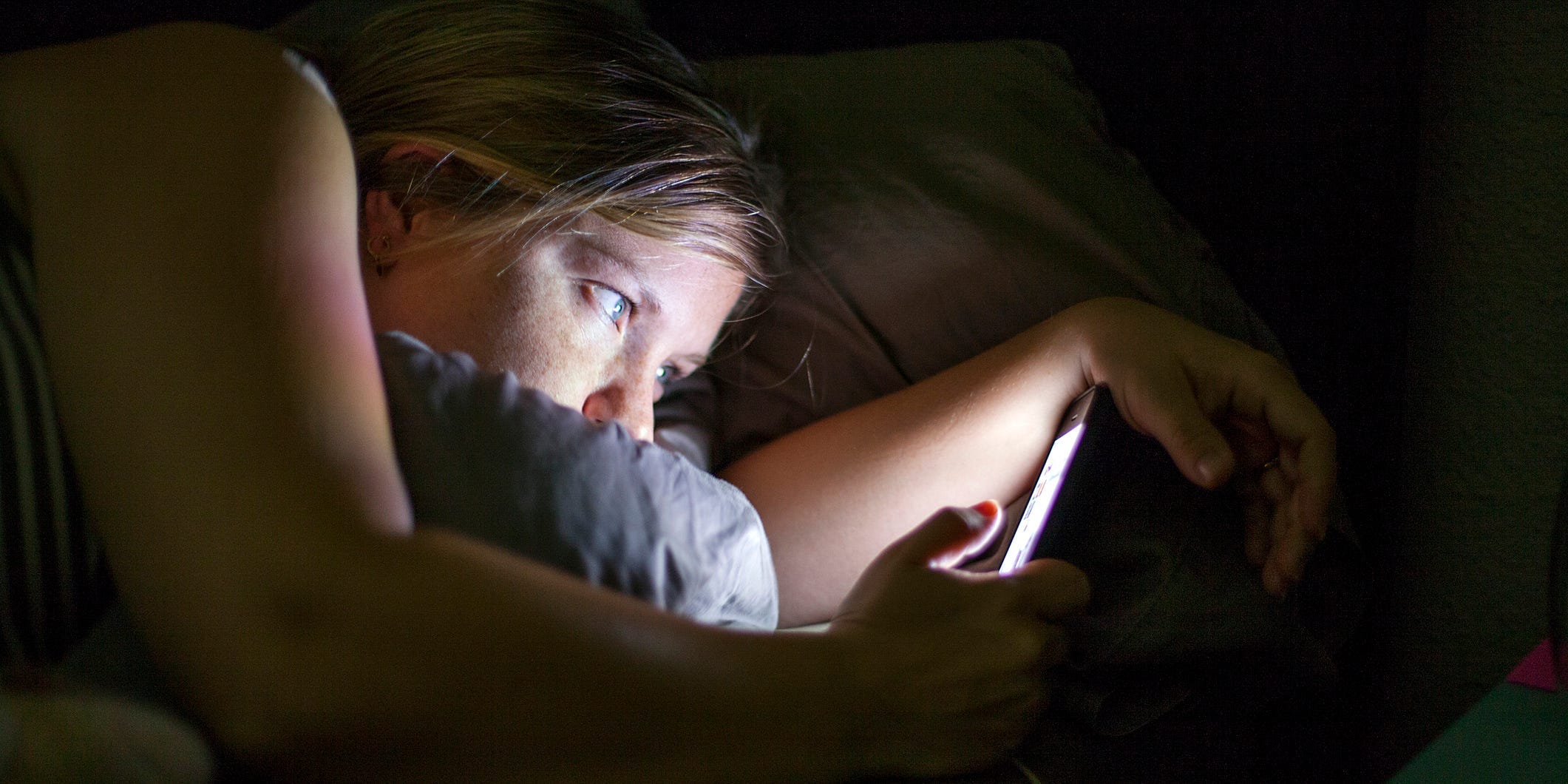woman on phone in bed