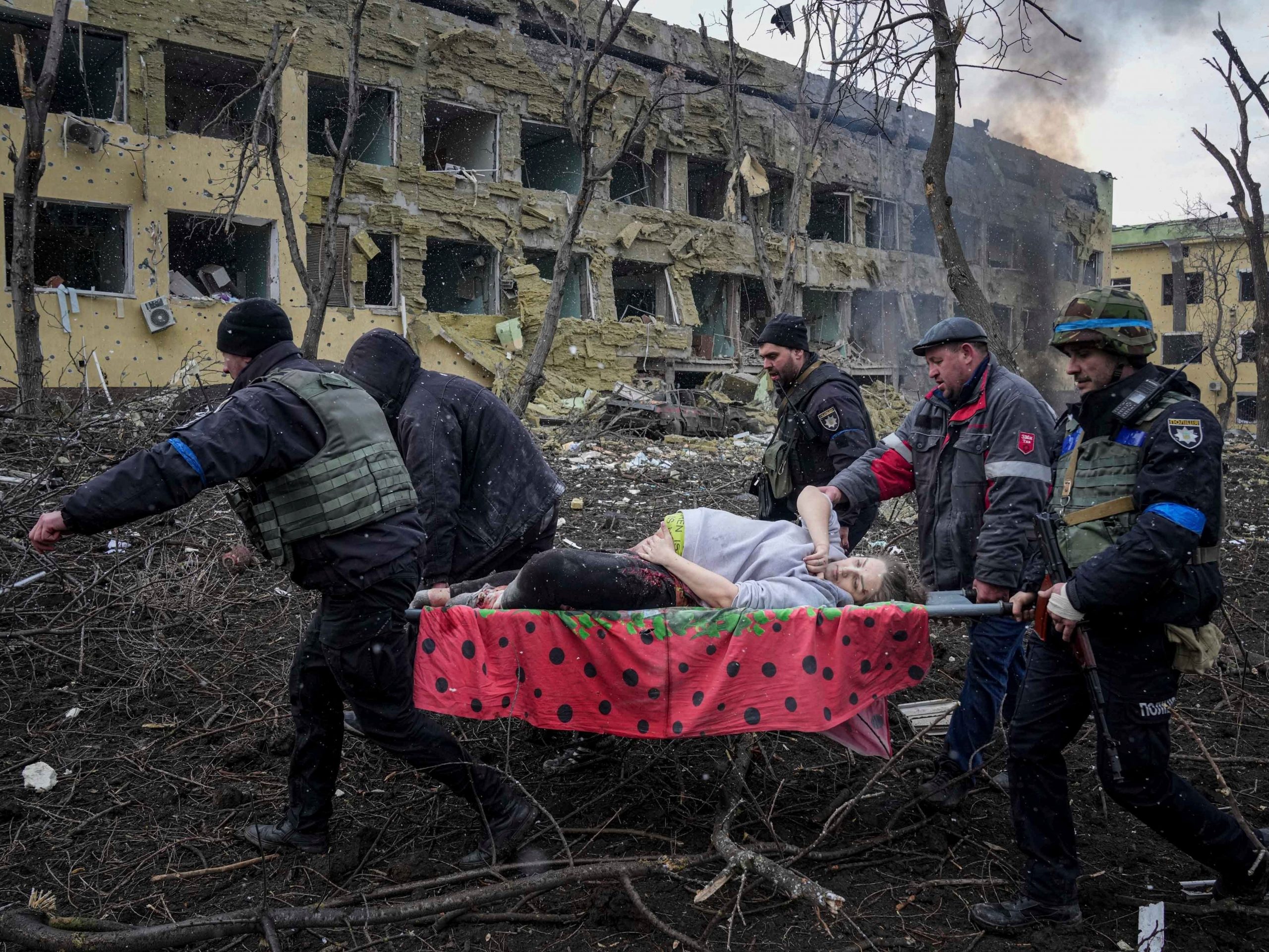 Ukrainian emergency employees and volunteers carry an injured pregnant woman from a maternity hospital that was damaged by shelling in Mariupol, Ukraine, March 9, 2022.