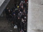 Bewoners steken de vernielde brug over terwijl ze vluchten uit de buitenwijk Irpin, Kiev.