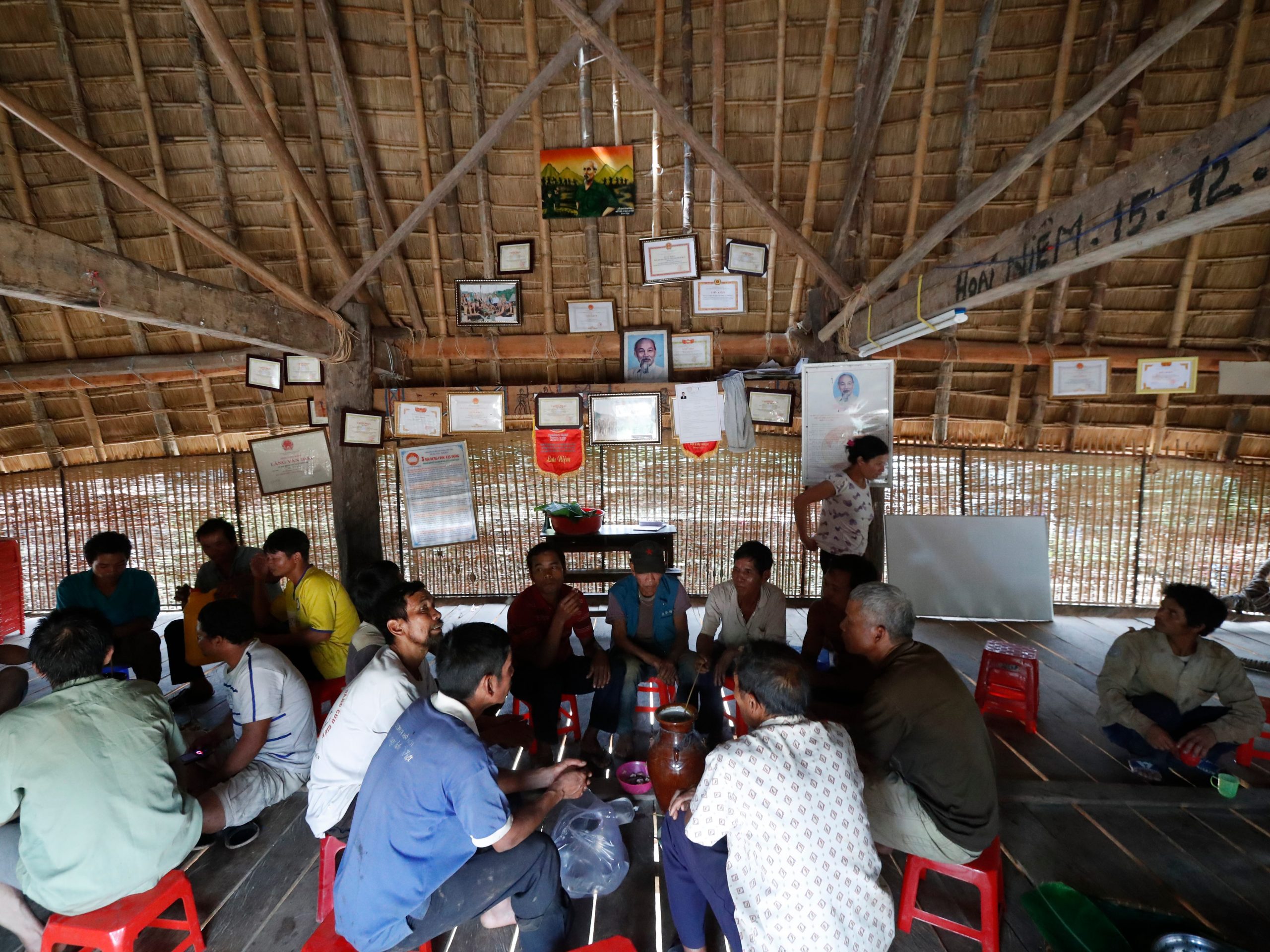 De Bahnar verzamelen zich in hun gemeenschappelijke Rong huis voor een dorpsbijeenkomst in Kon Tum, Vietnam.