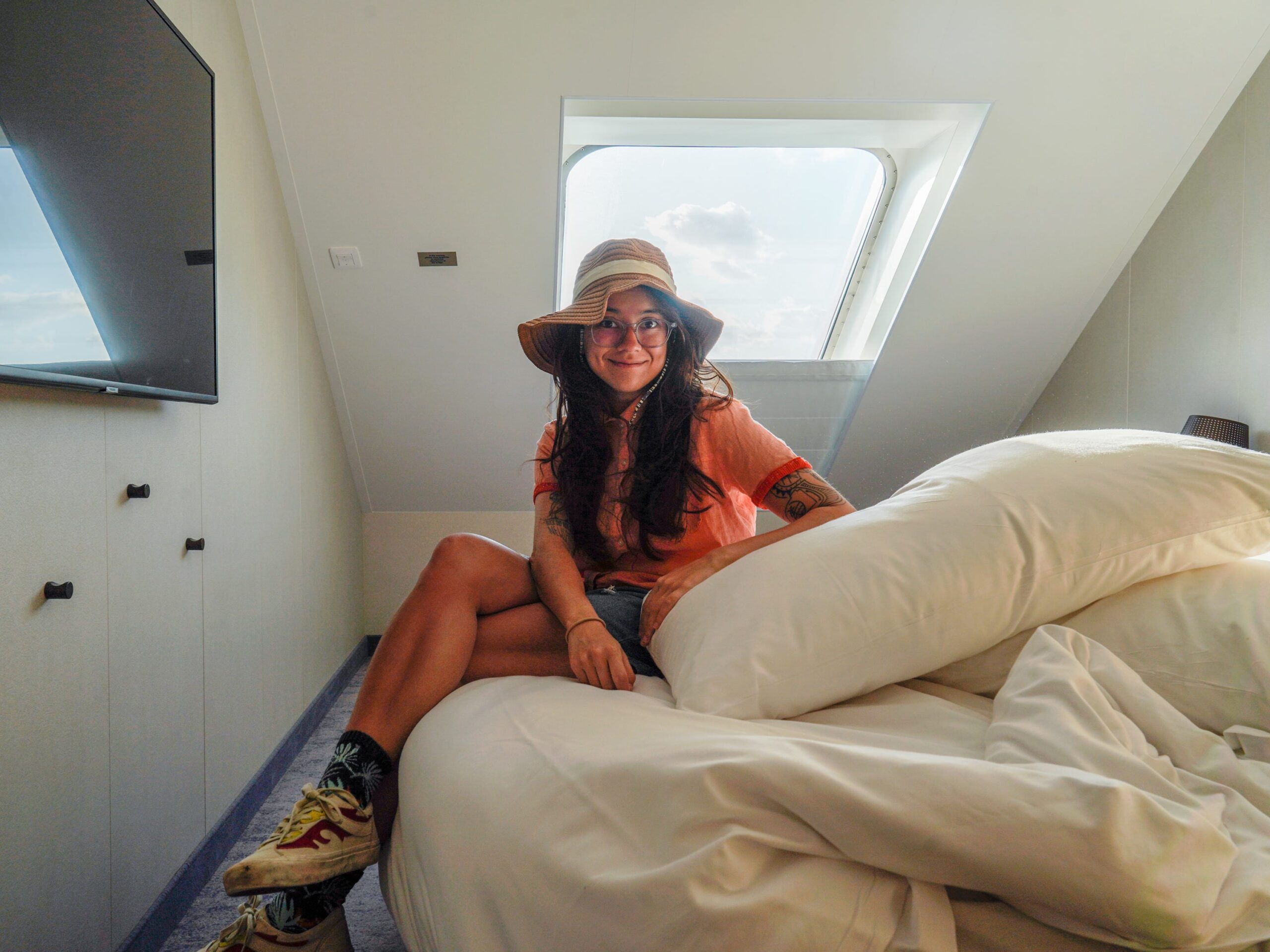 the author sits on the bed on the world&#39;s largest cruise ship