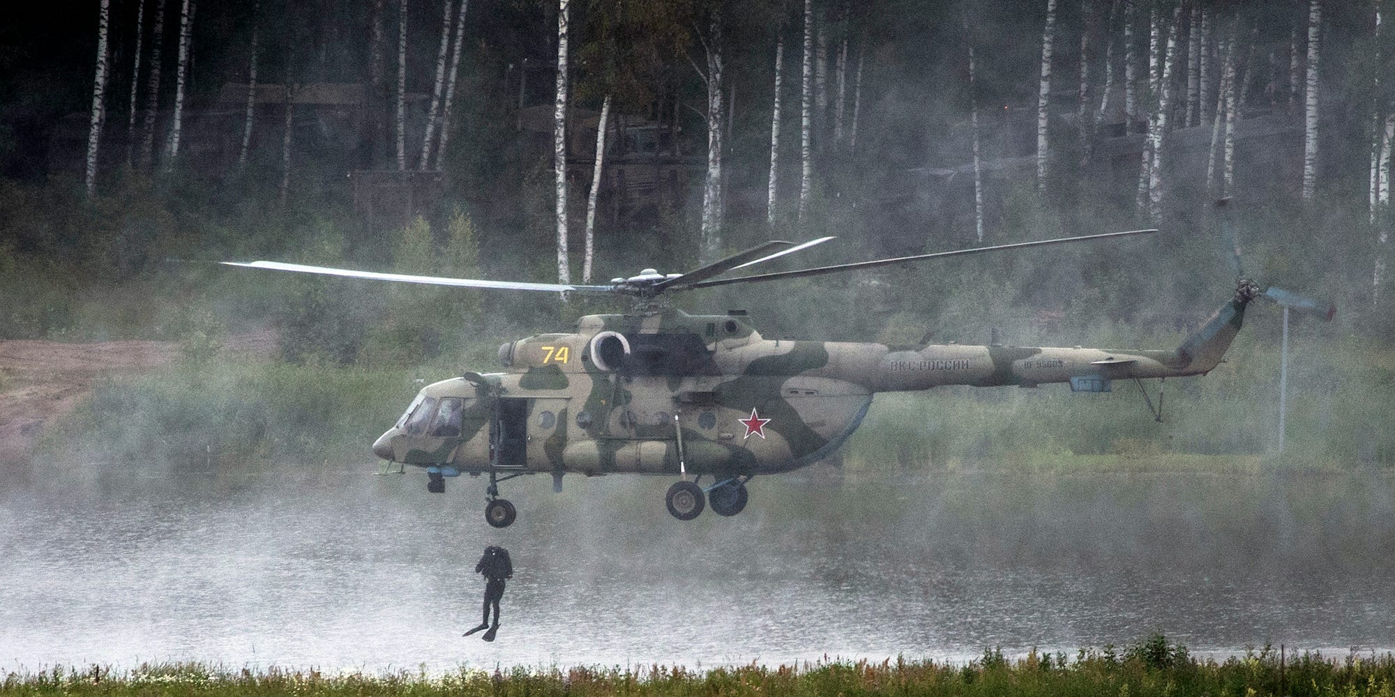 Een Russische soldaat van de speciale strijdkrachten laat zich vanuit de Mi-17-helikopter in een meer vallen tijdens het International Military Technical Forum Army.