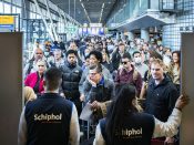 Reizigers in een volle vertrekhal op Schiphol