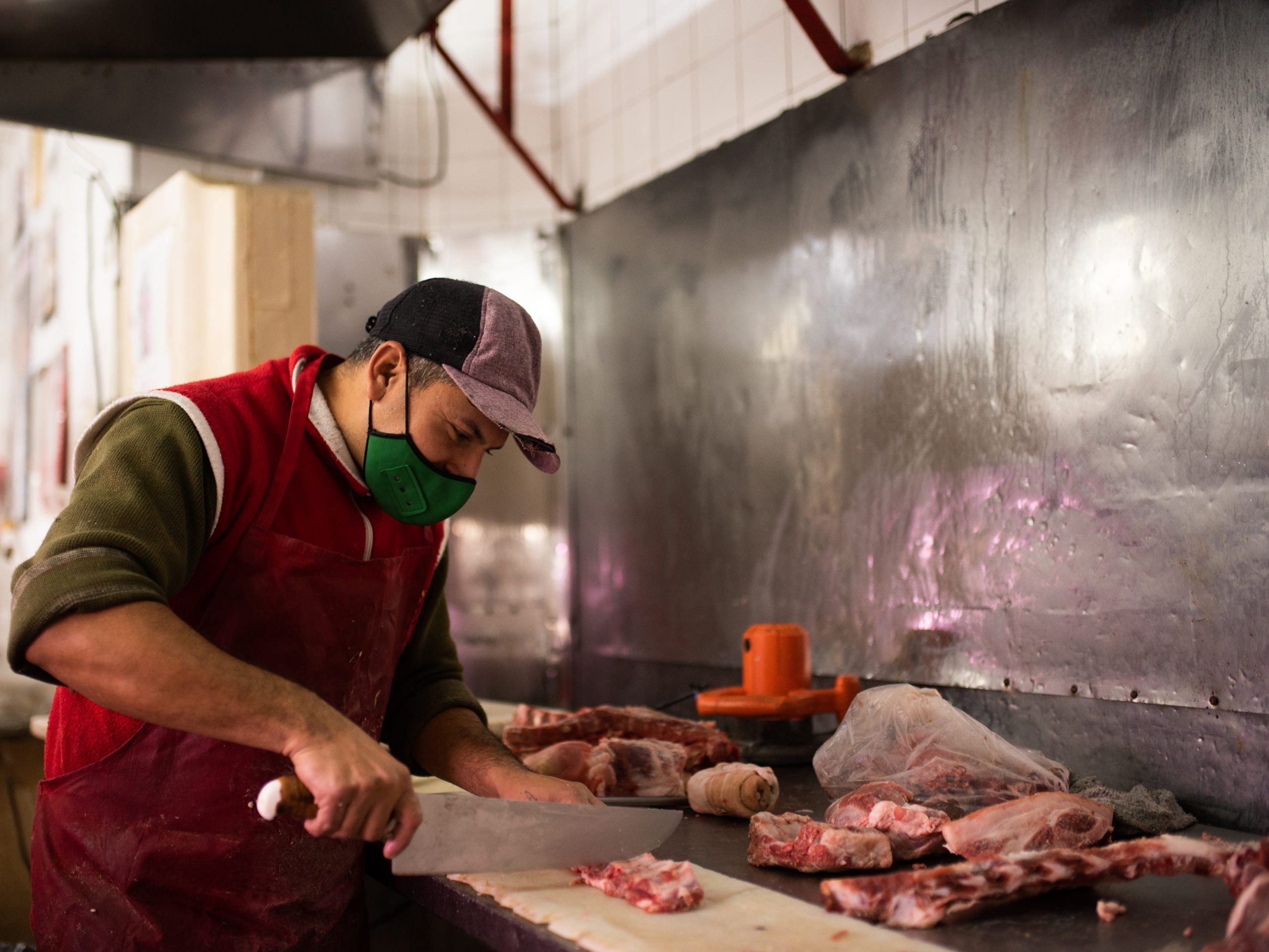 Een slager snijdt een stuk vlees