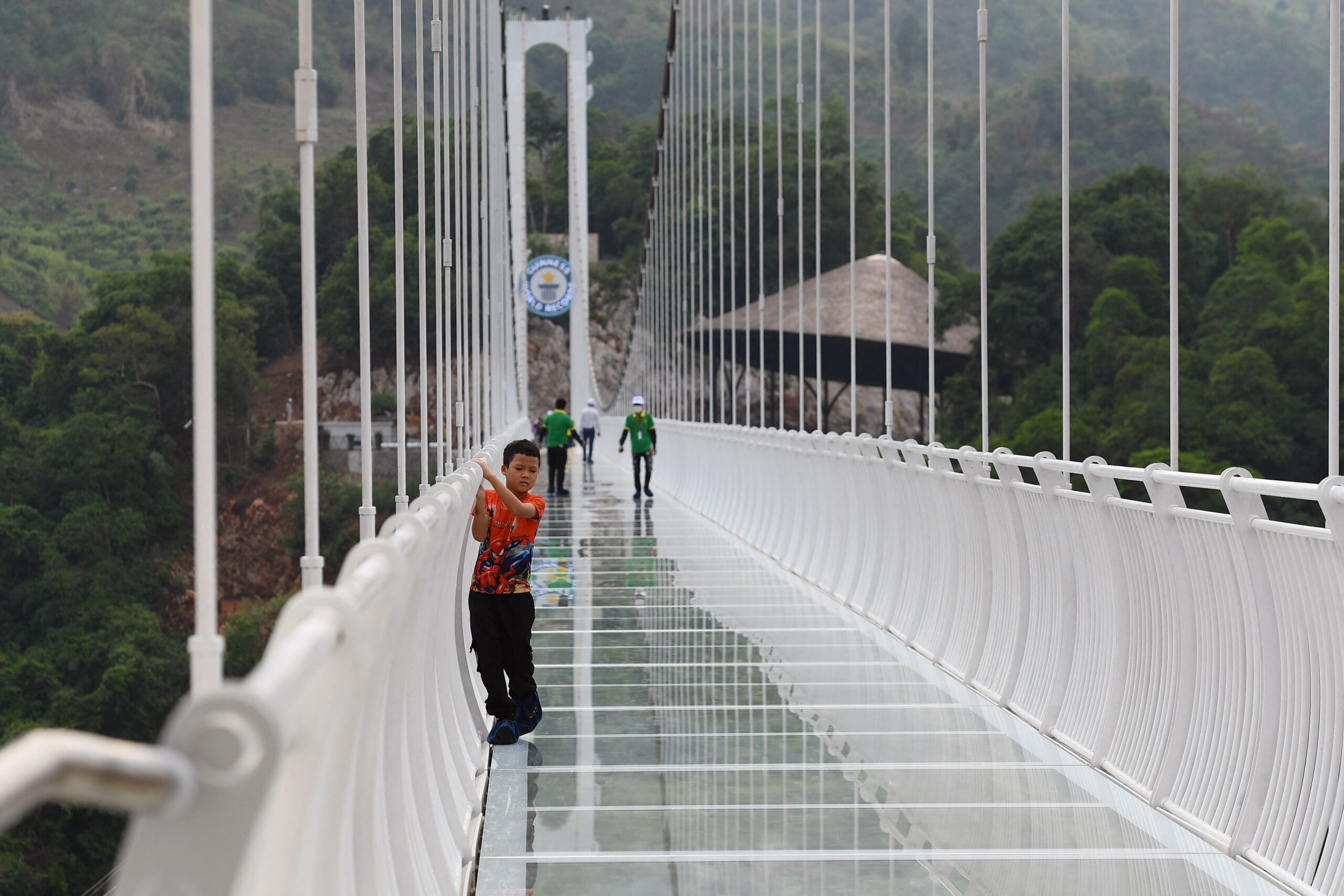 a child clings to the railing on the Bach Long glass bridge in the Moc Chau district in Vietnam&#39;s Son La province