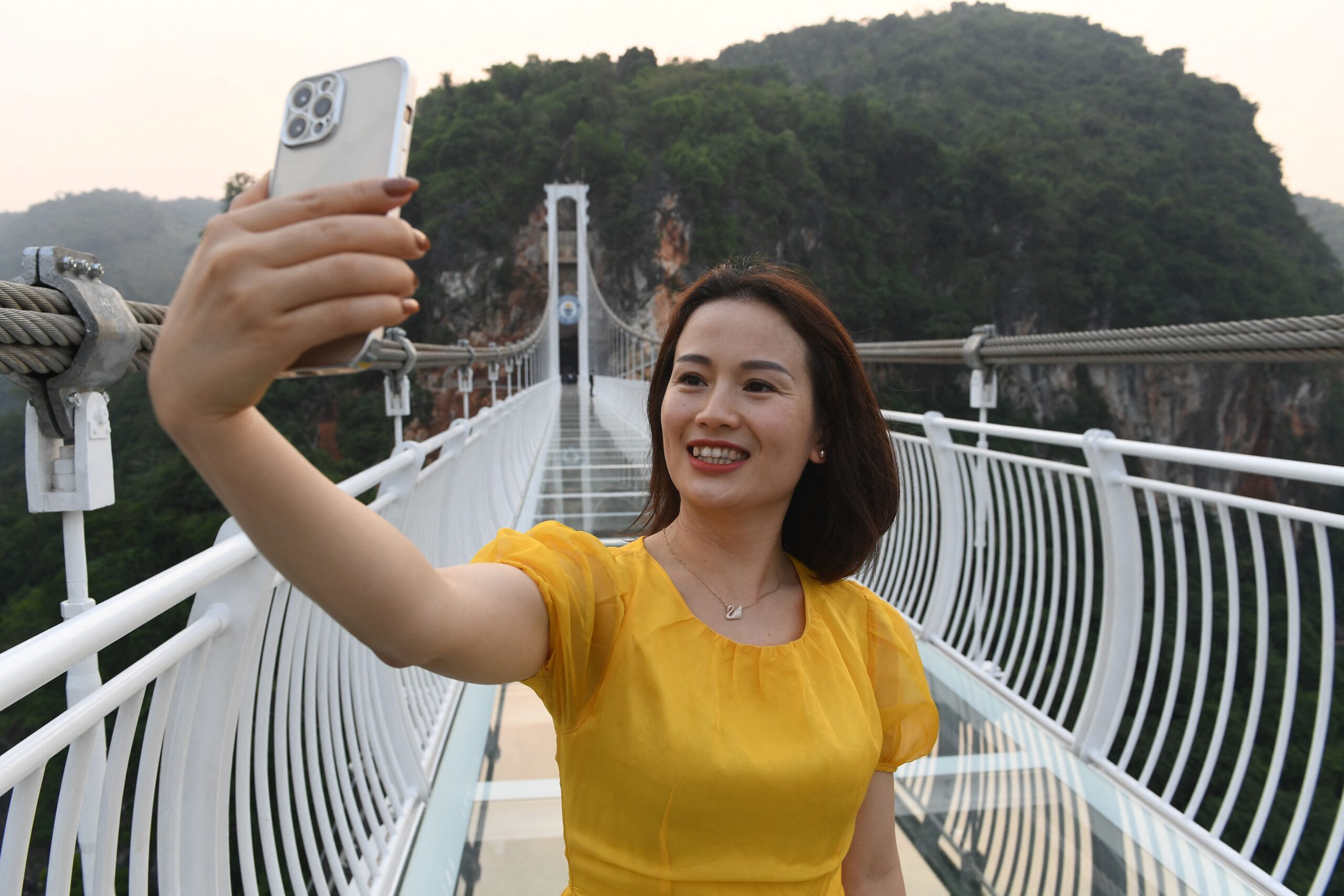 a woman takes a selfie on the Bach Long glass bridge in the Moc Chau district in Vietnam&#39;s Son La province