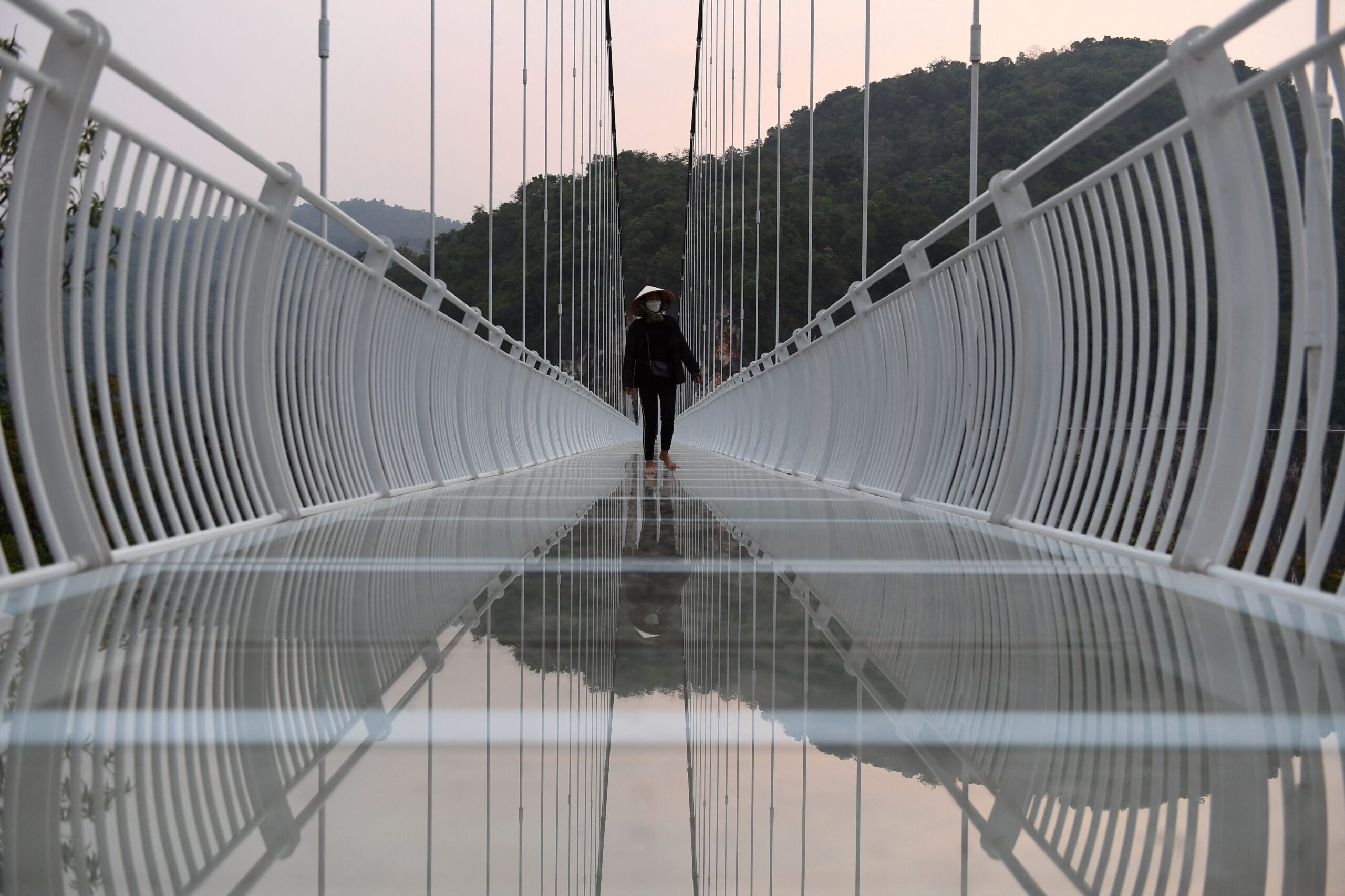 a person walks on the Bach Long glass bridge in the Moc Chau district in Vietnam&#39;s Son La province