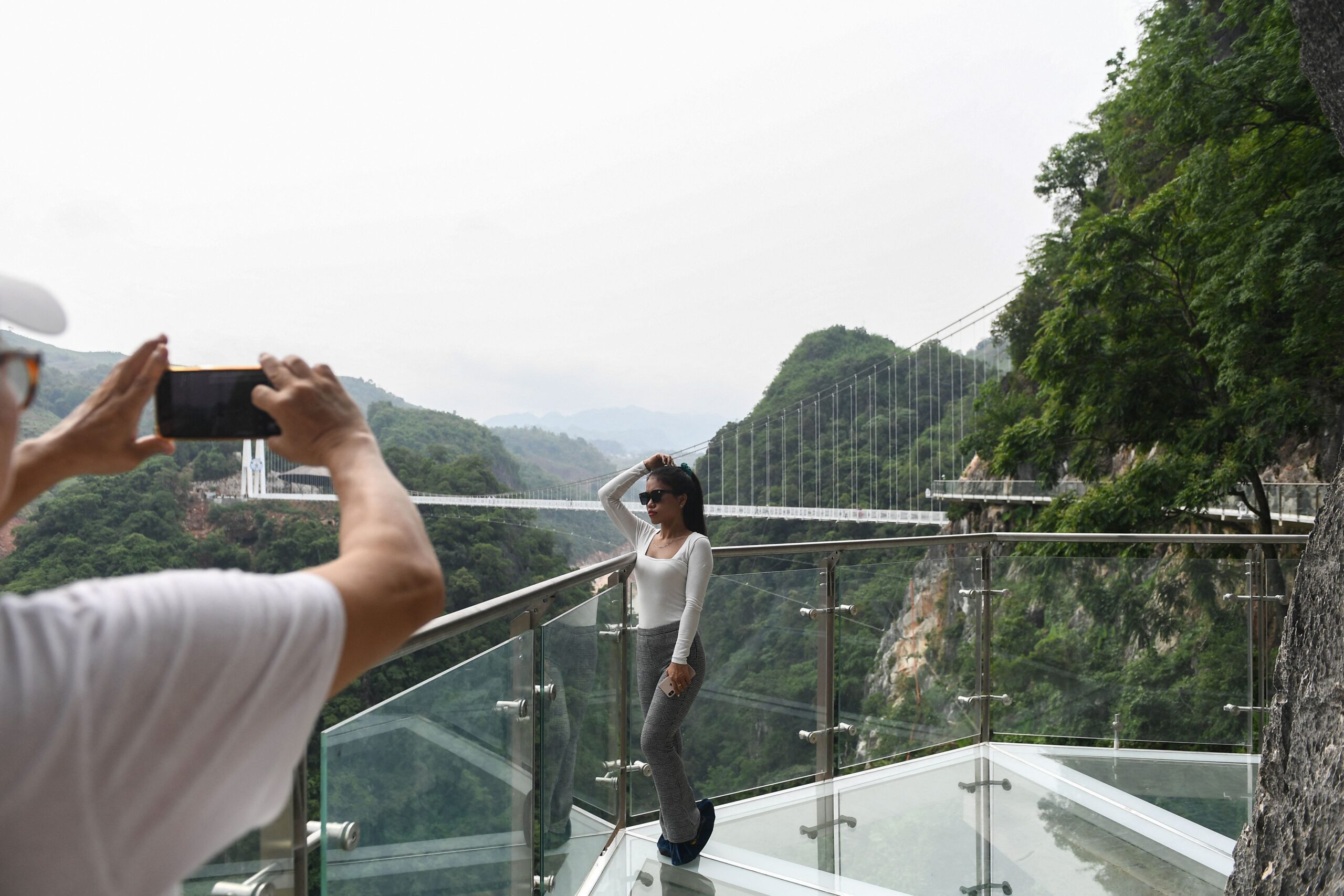 people take pictures on the Bach Long glass bridge in the Moc Chau district in Vietnam&#39;s Son La province