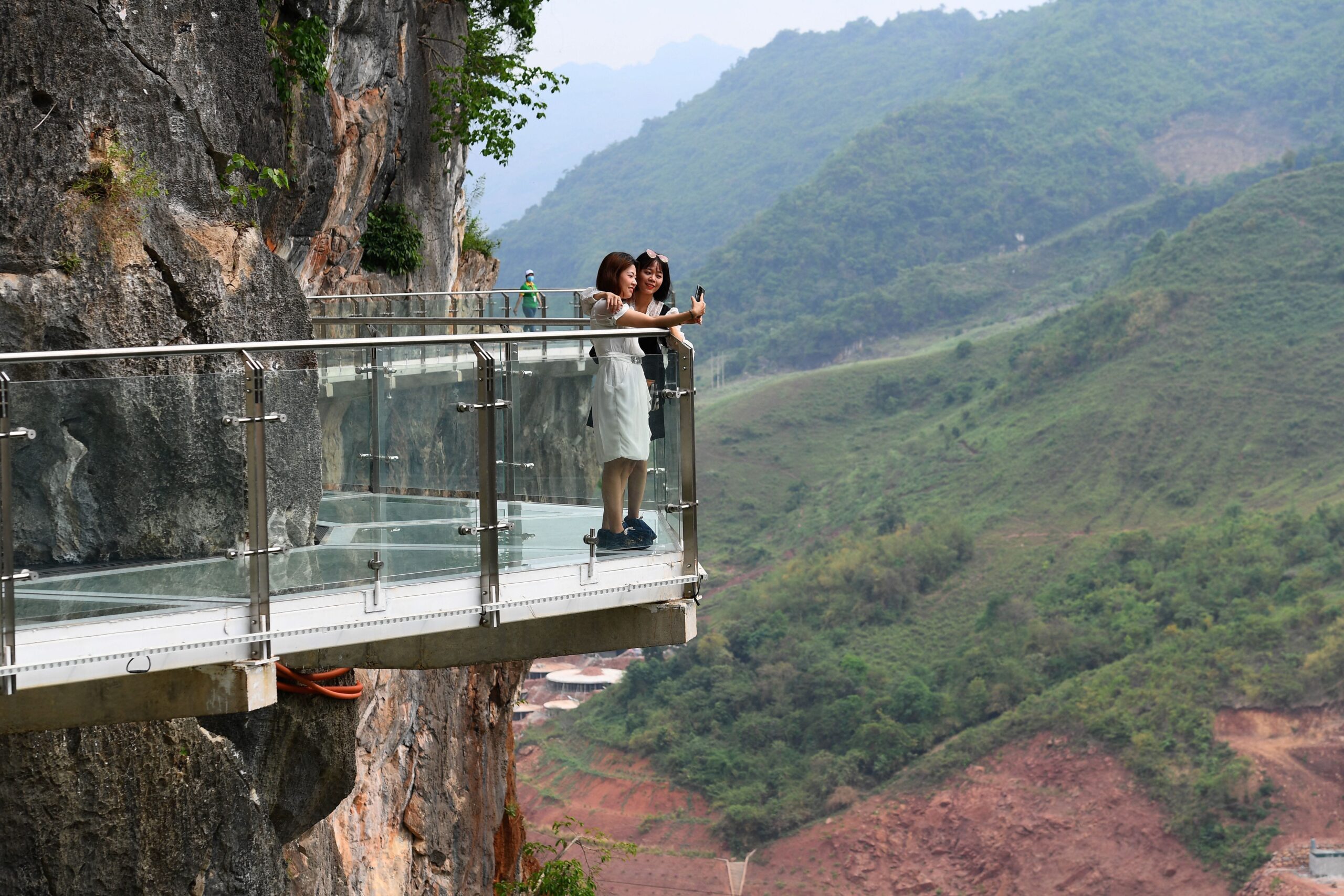 people stand on the Bach Long glass bridge in the Moc Chau district in Vietnam&#39;s Son La province