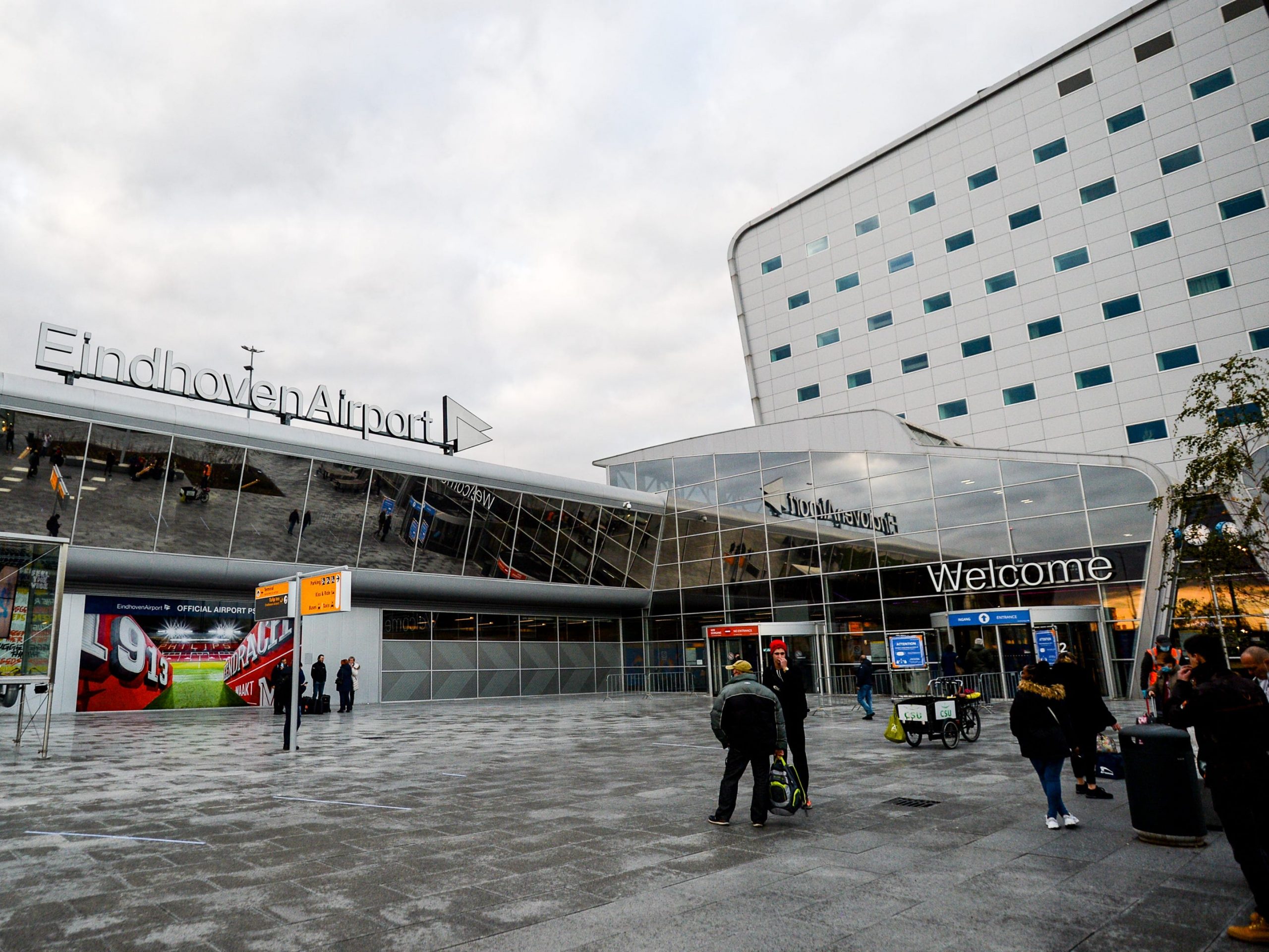 Reizigers bij de hoofdingang van Eindhoven Airport op 20 november 2020 in Eindhoven.