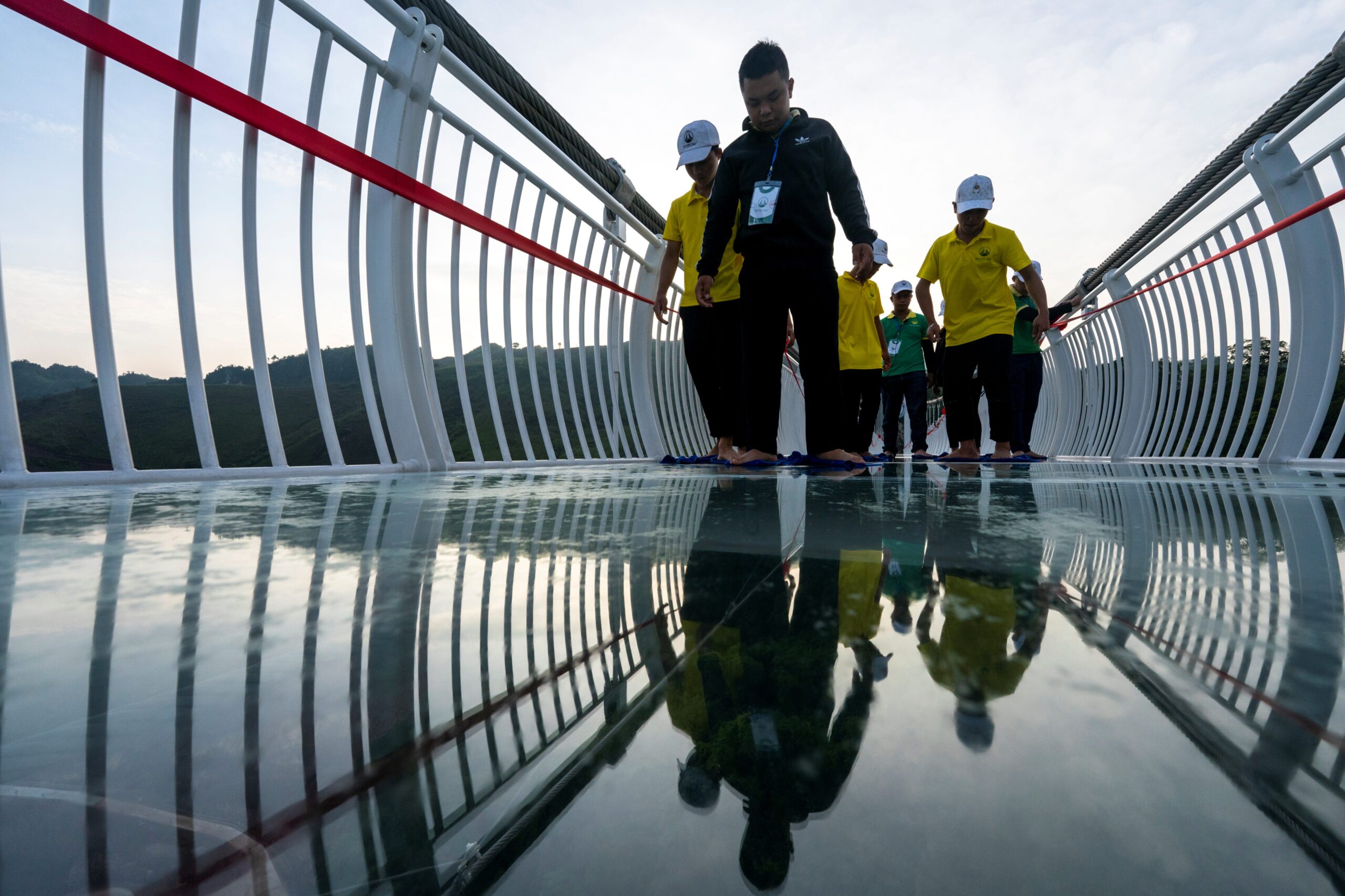 Workers clean the Bach Long glass bridge ahead of the opening ceremony at Moc Chau district in Son La province, Vietnam, May 28, 2022. Picture taken May 28, 2022.