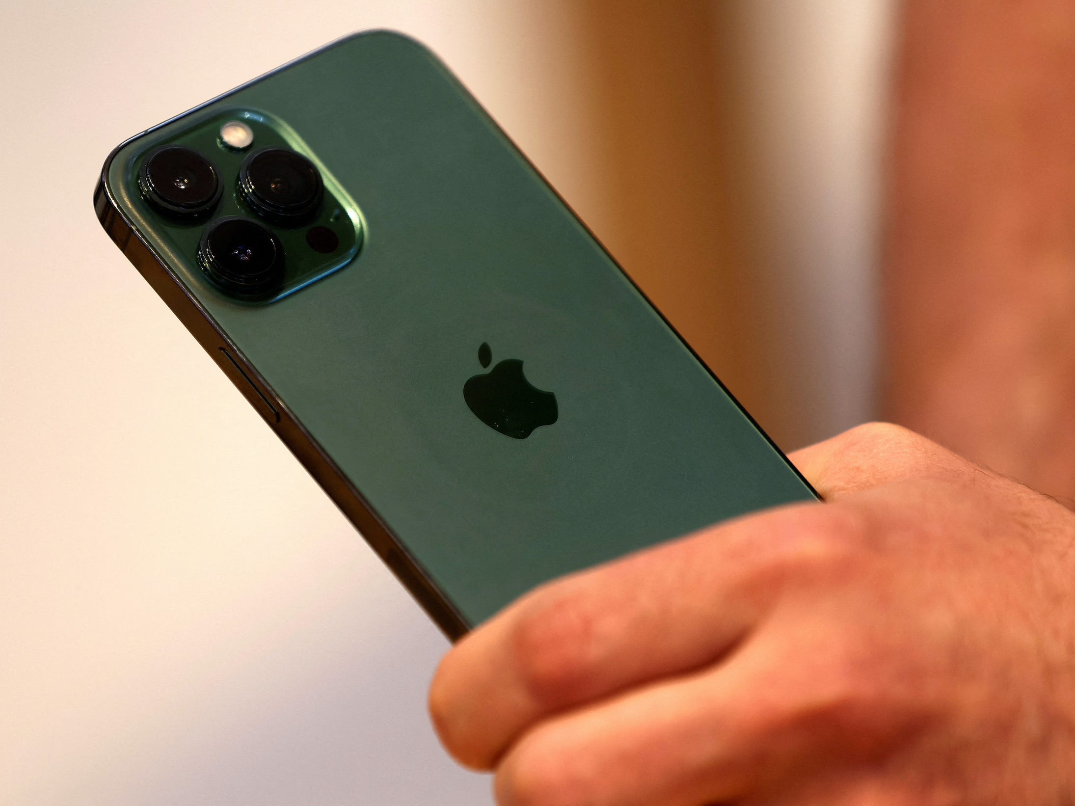 Hand holds Apple&#39;s new green iPhone 13 Pro