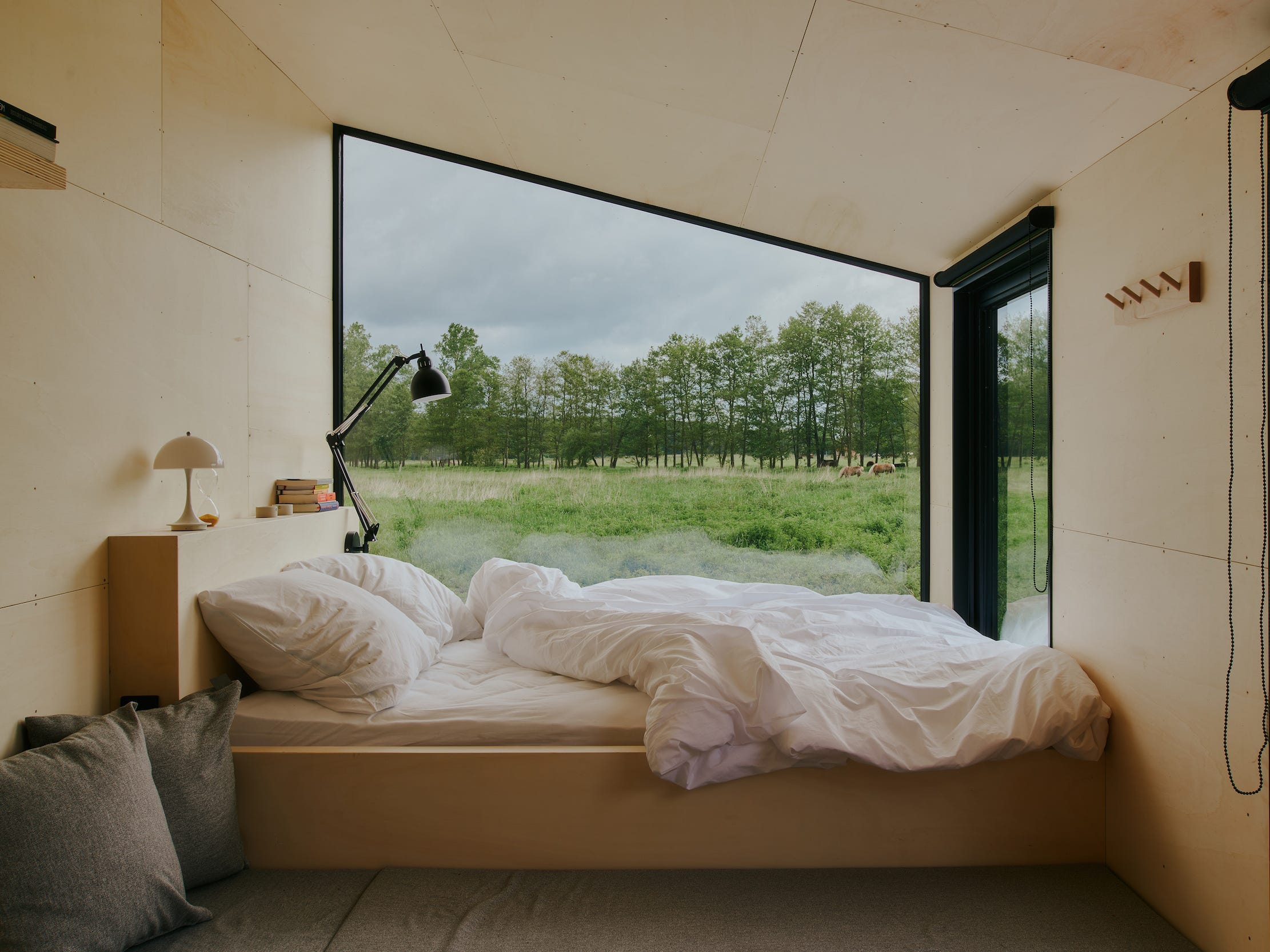 Een kijkje in een Raus-huisje met een bed bij het raam.