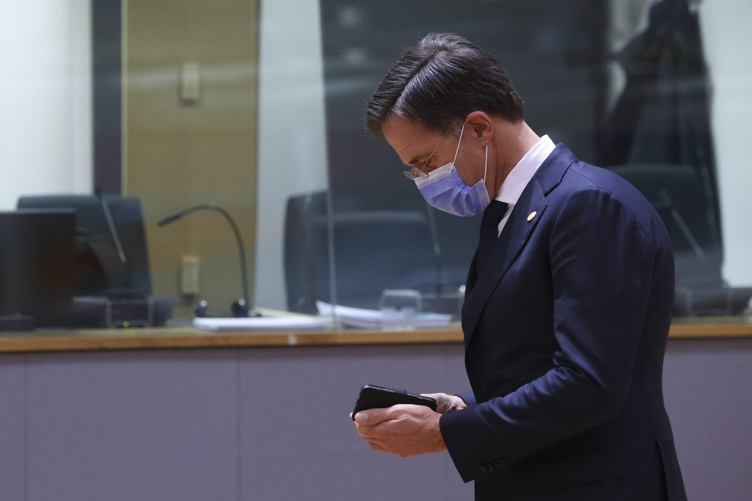 Premier Mark Rutte kijkt op zijn telefoon tijdens EU-top in Brussel over onder meer de coronapandemie. Foto: EPA/Yves Herman