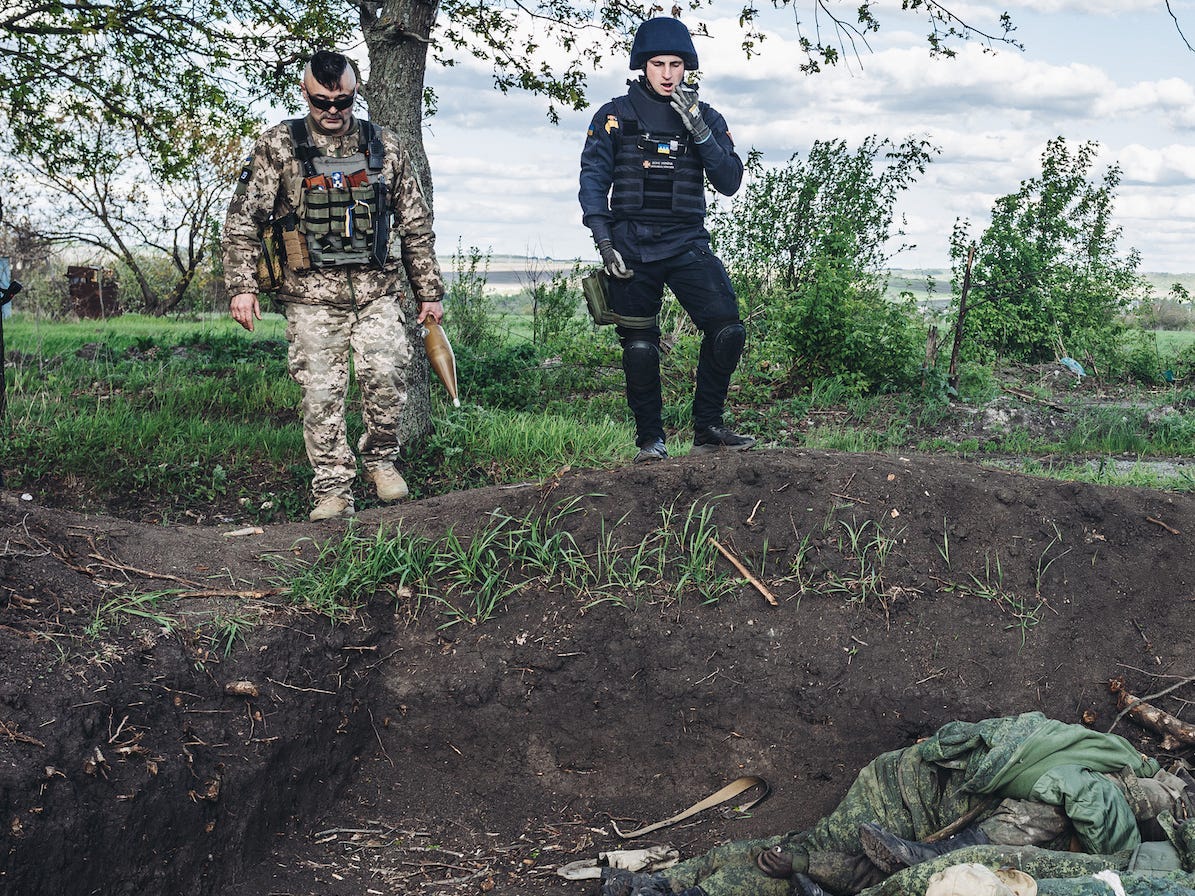 Oekraïense soldaten bij een graf met Russsische gesneuvelden in de buurt van Charkov. 