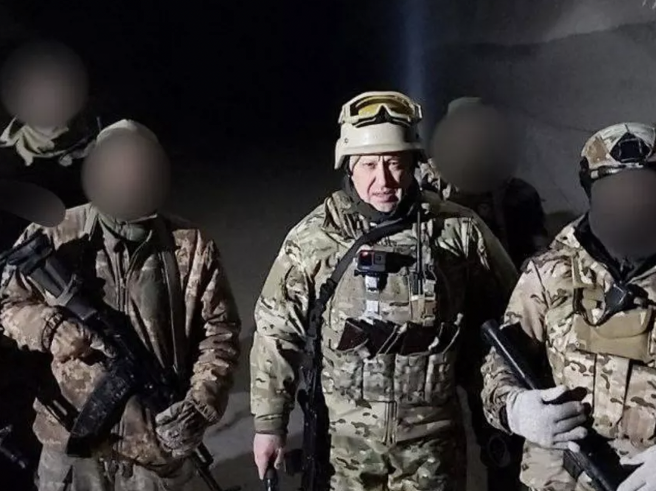 Wagner Group chief Yevgeny Prigozhin in military gear with several others, whose faces have been blurred, in what Russian state media described as the salt mines of Soledar, eastern Ukraine, on January 10 2022.
