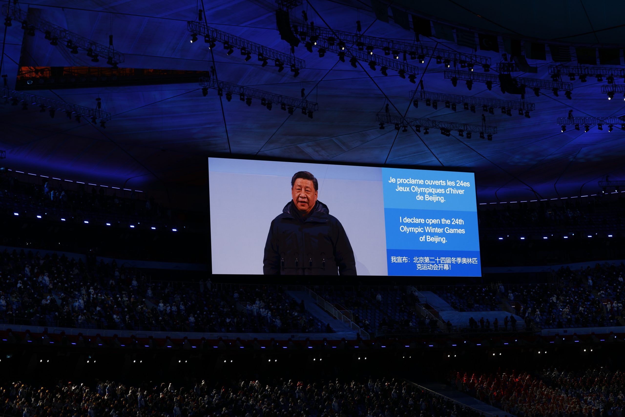 De Chinese president Xi Jinping op groot scherm tijdens de openingsceremonie van de Olympische Winterspelen 2022 in 'het Vogelnest' in Beijing. 