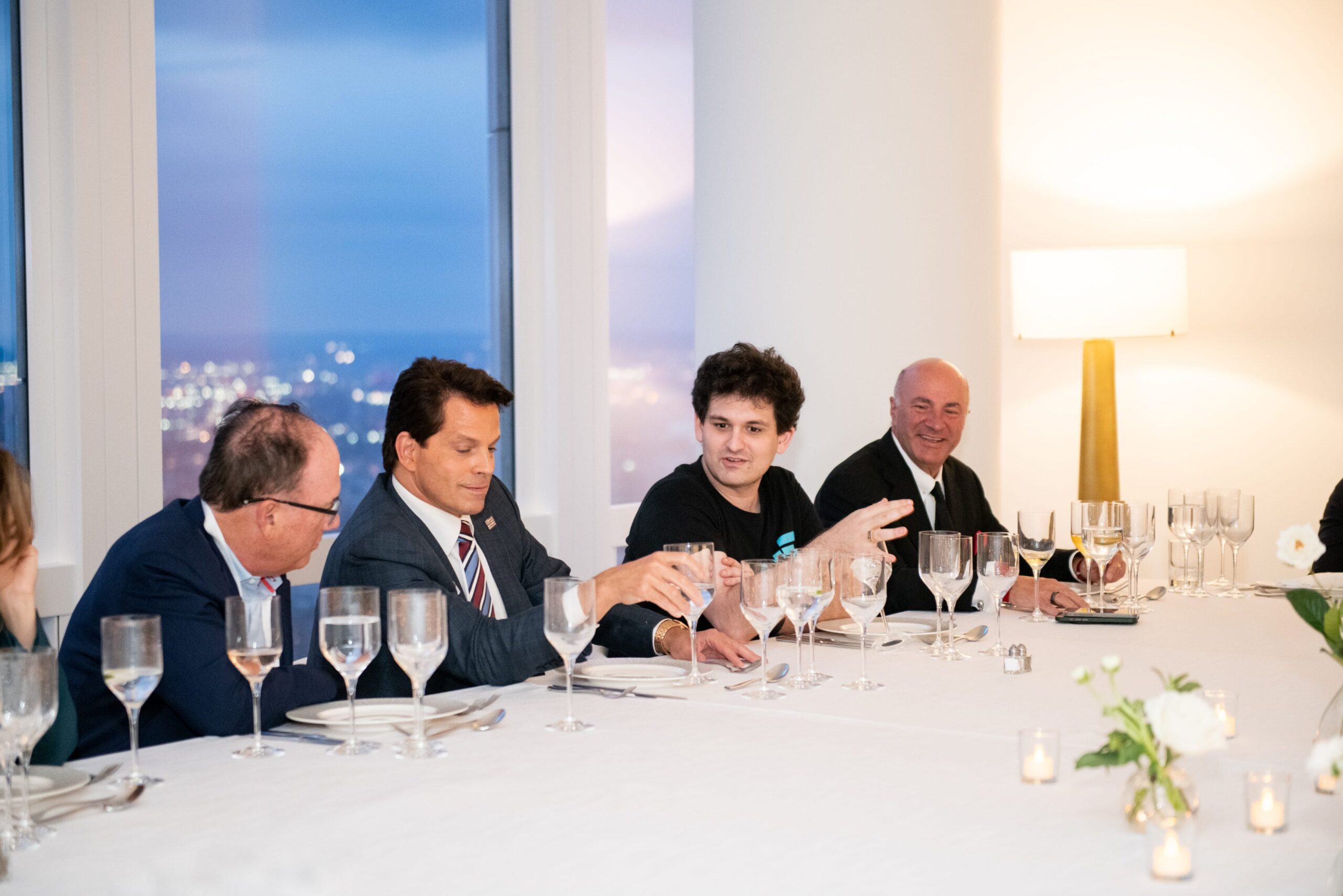 Sam Bankman-Fried is shown sitting at a long white table having dinner with Anthony Scaramucci  and Shark Tank investor Kevin O&#39;Leary.