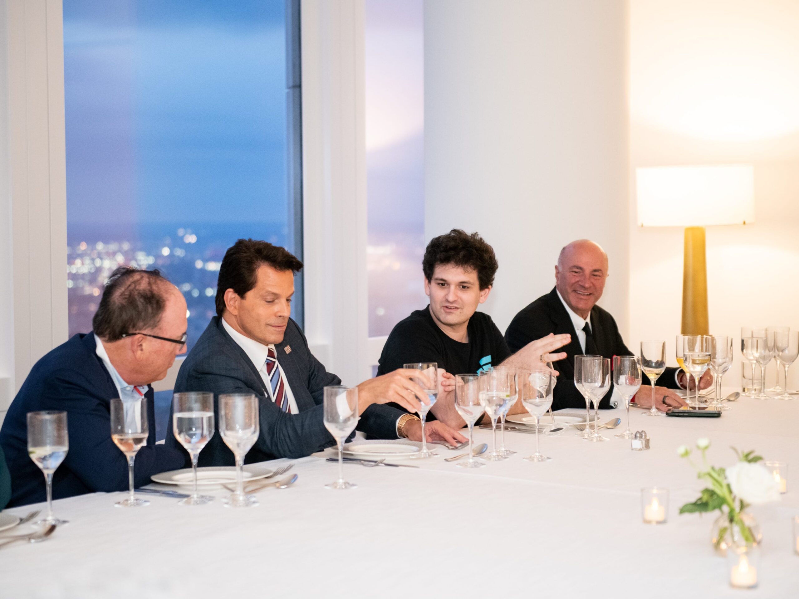 Sam Bankman-Fried is shown sitting at a long white table having dinner with Anthony Scaramucci  and Shark Tank investor Kevin O&#39;Leary.